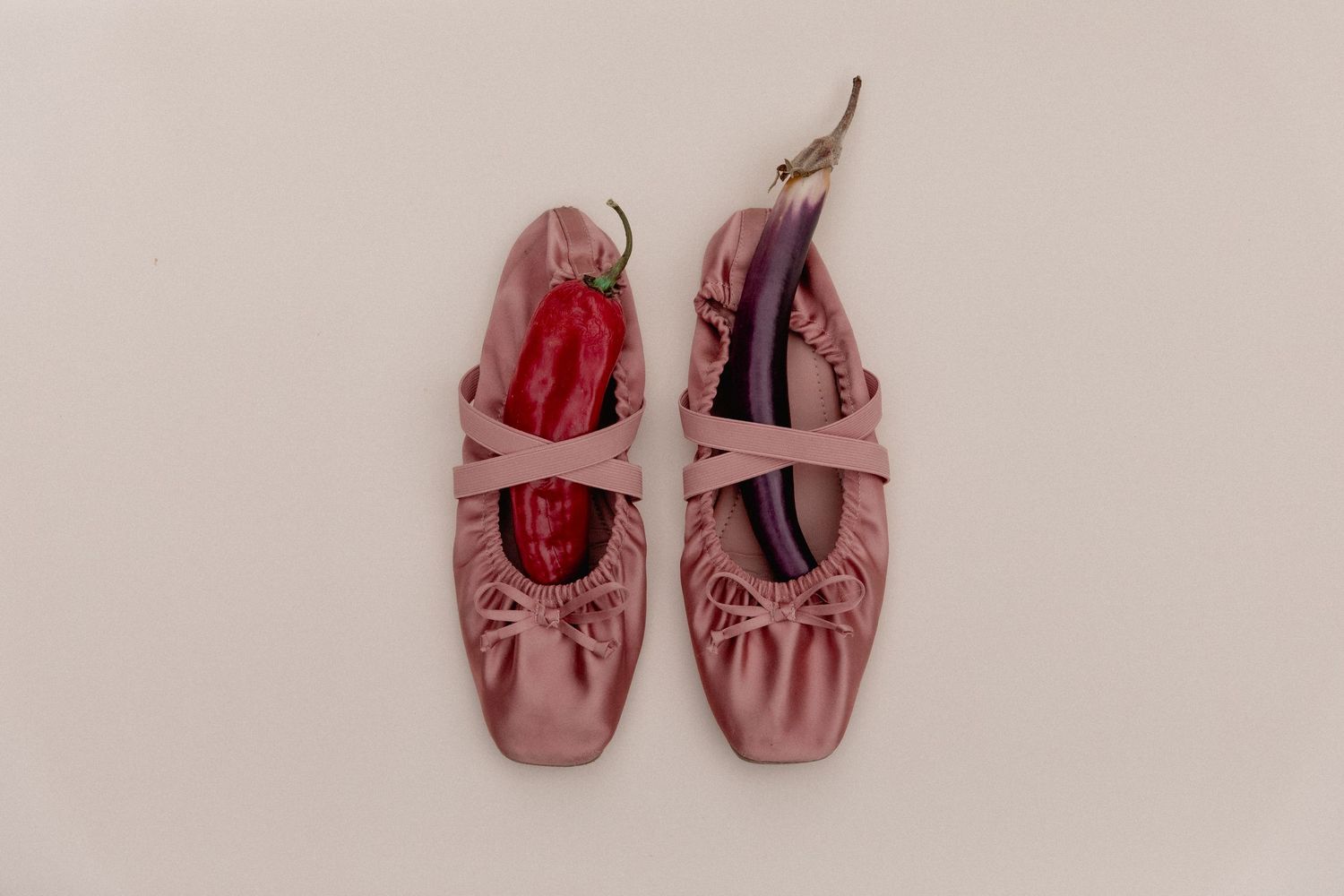 Pink leather ballet flats with elastic straps and gathered details shown from different angles on beige background.