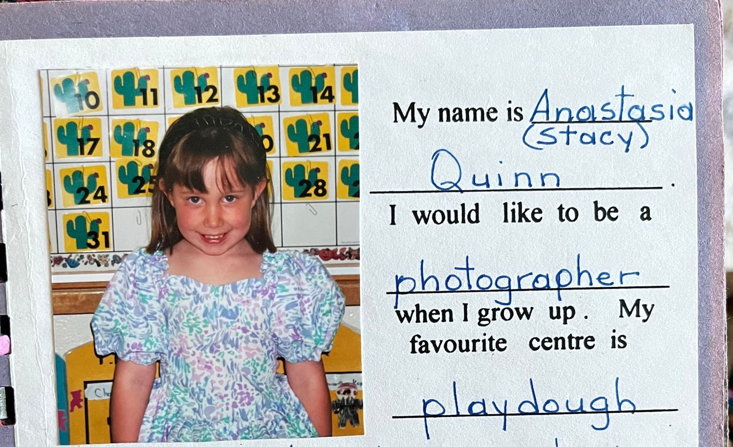 Young girl named Anastasia Quinn poses for school photo, aspiring to be a photographer, with playdough as her favourite centre.
