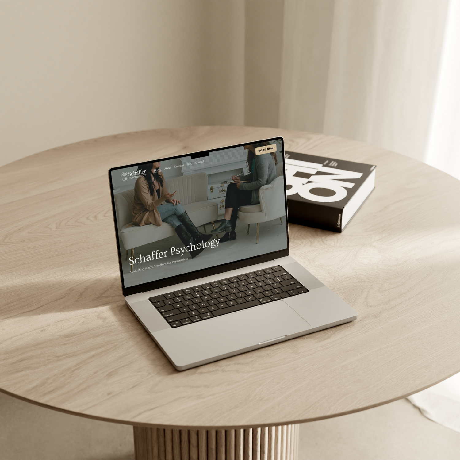 Modern laptop computer with reflective screen sitting on a light colored circular table surface.