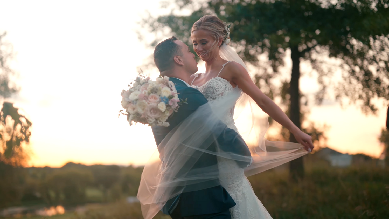 A romantic sunset dance moment captured during an outdoor wedding celebration.