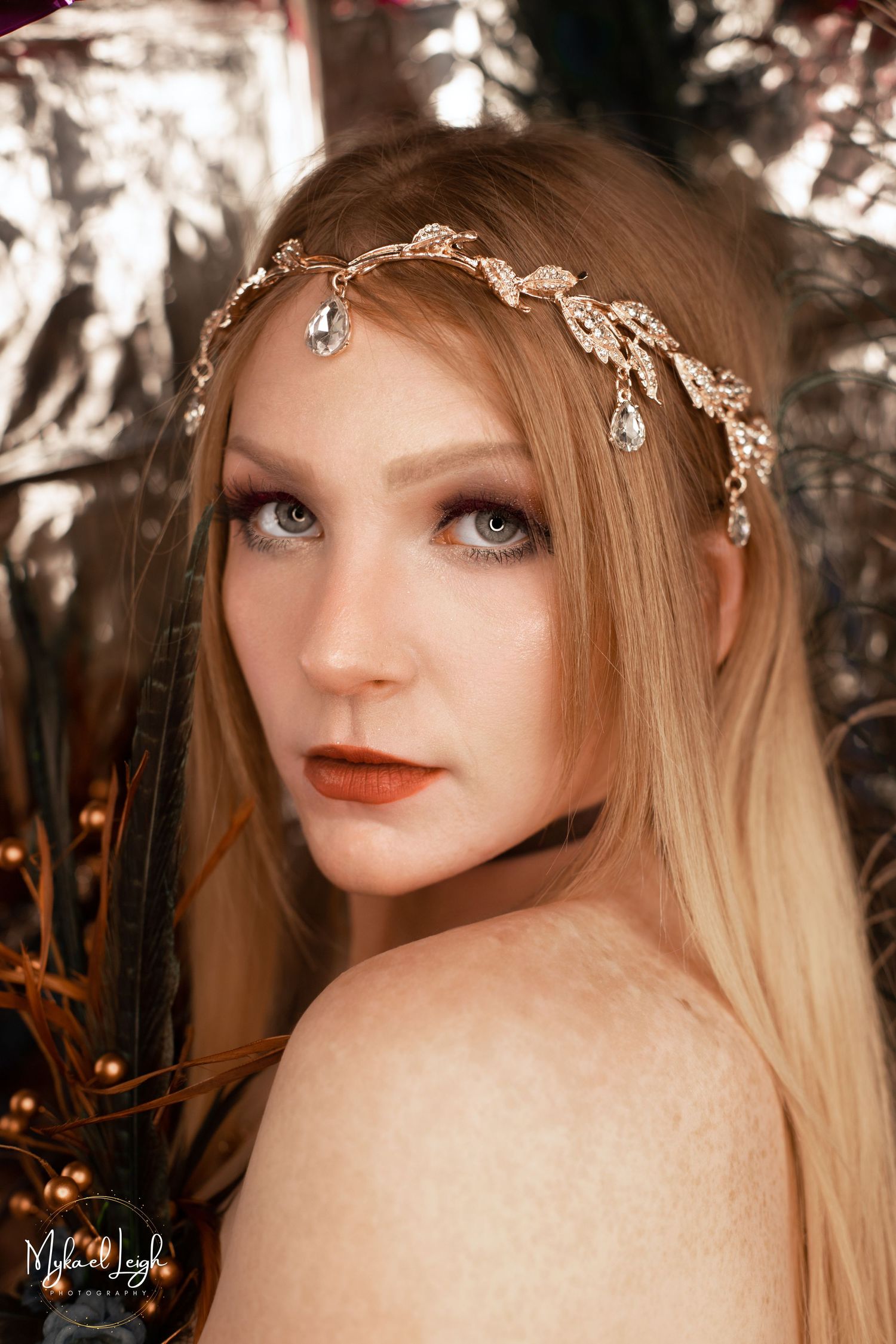 A fantasy-inspired portrait with crystal leaf headpiece and bronze tones against a bokeh backdrop.