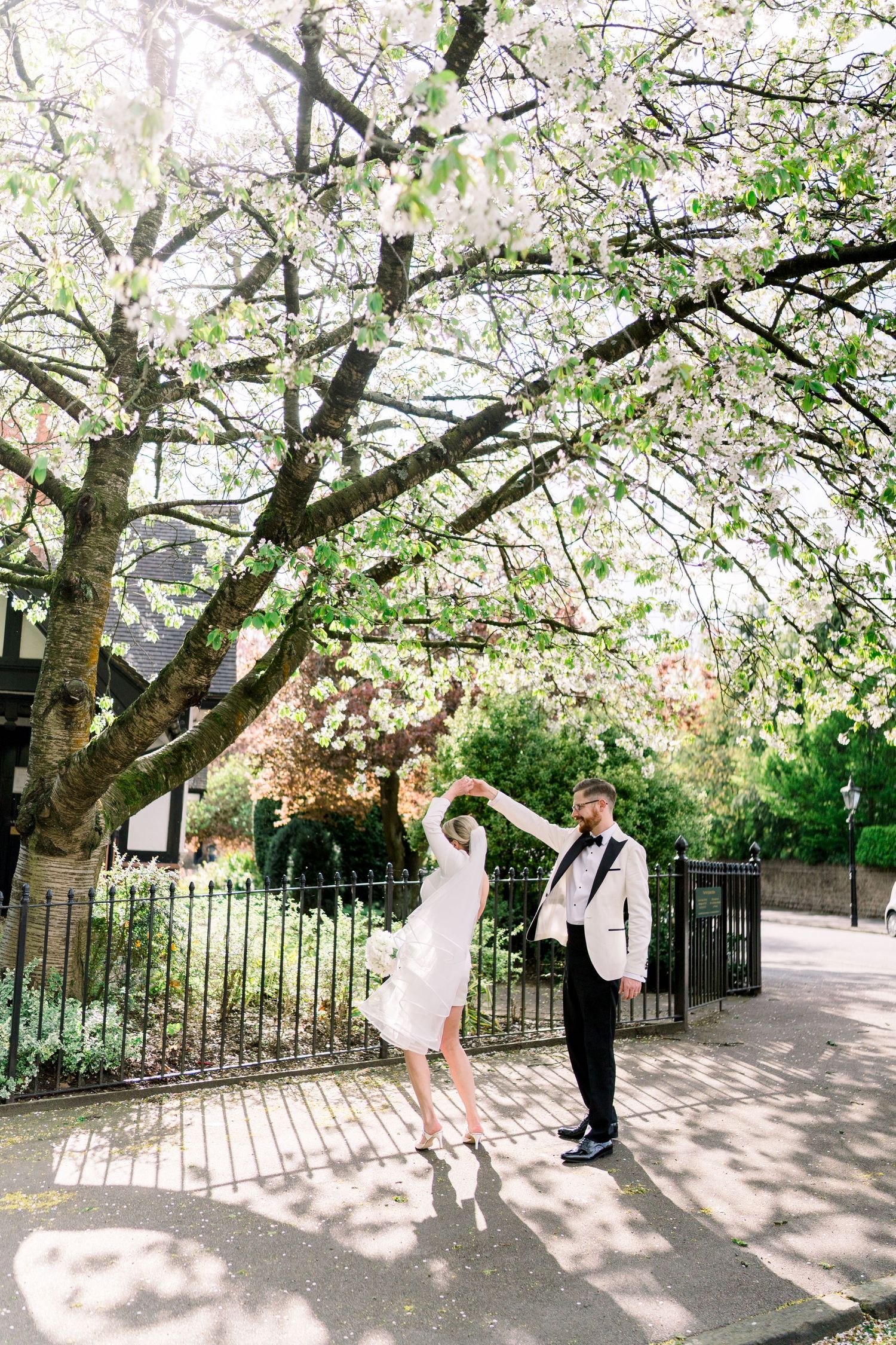 Groom twirling bride, sharing intimate moments beneath the greenery of The Park Estate during their relaxed Nottingham city centre elopement