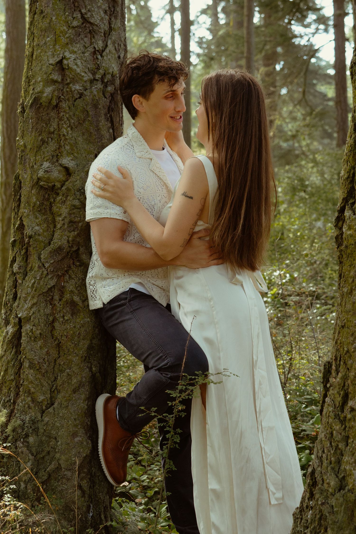 Cinematic moment of a couple sharing an intimate moment at Deception Pass, WA during an engagement session, Captured by Savvy Photography.