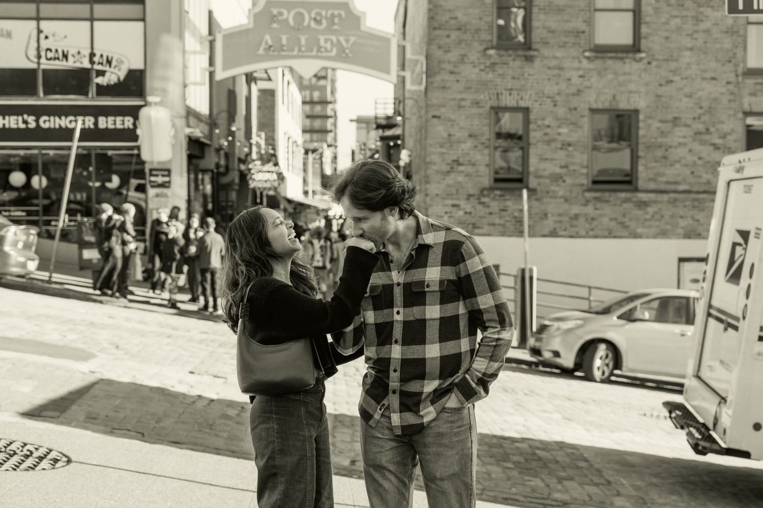 Black and white photo of a couple at Post Alley in Seattle. Captured by Savvy Photography