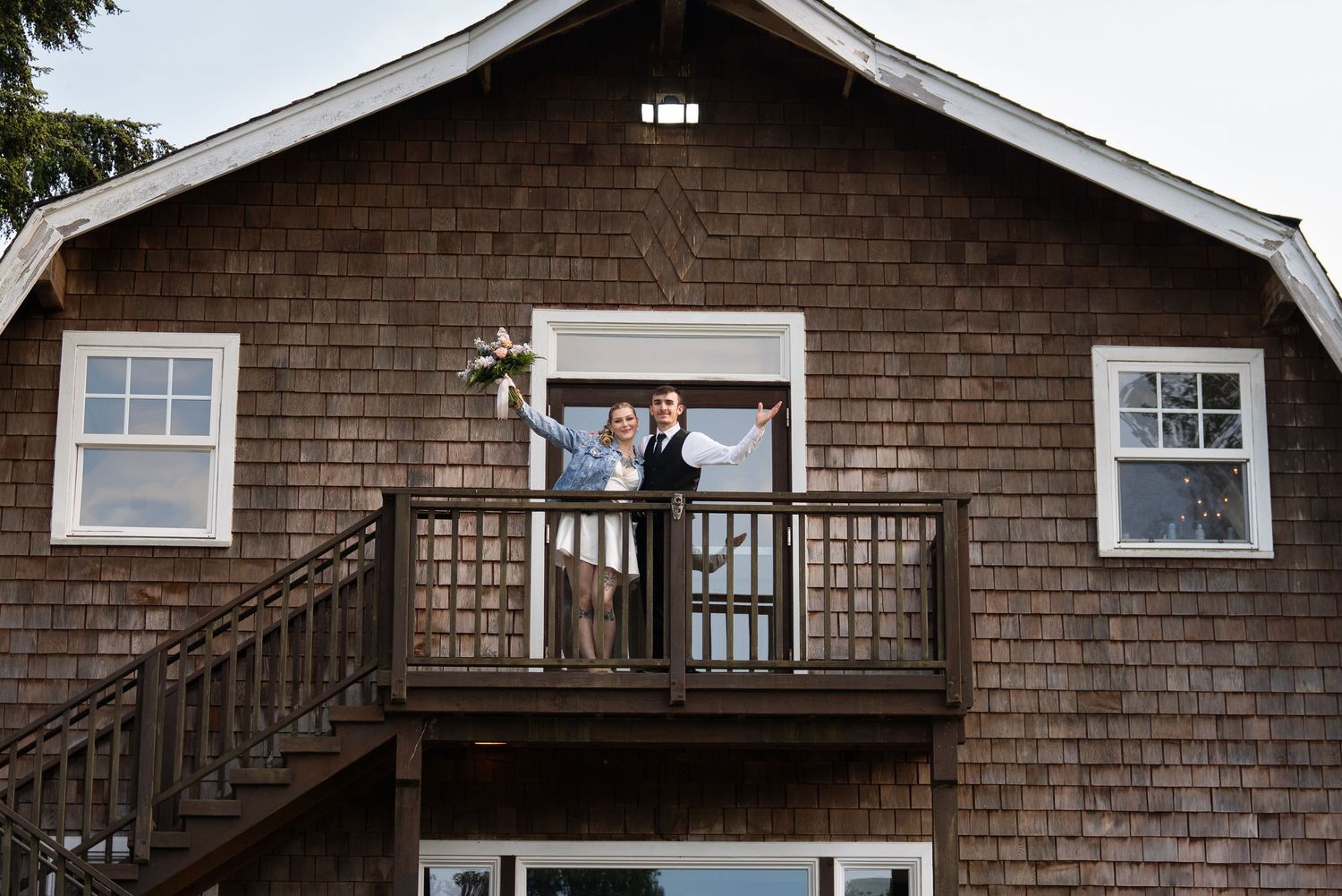 A bride and groom waving out at Sadie Lake Events Wedding Venue. Captured by Savvy Photography - Seattle Wedding Photographer