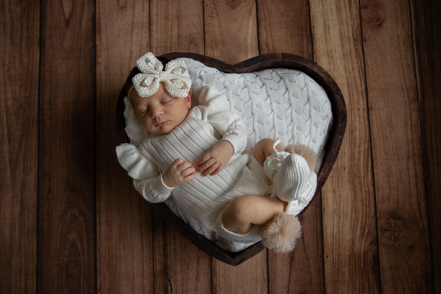 Newborn baby posed in a little love heart prop.