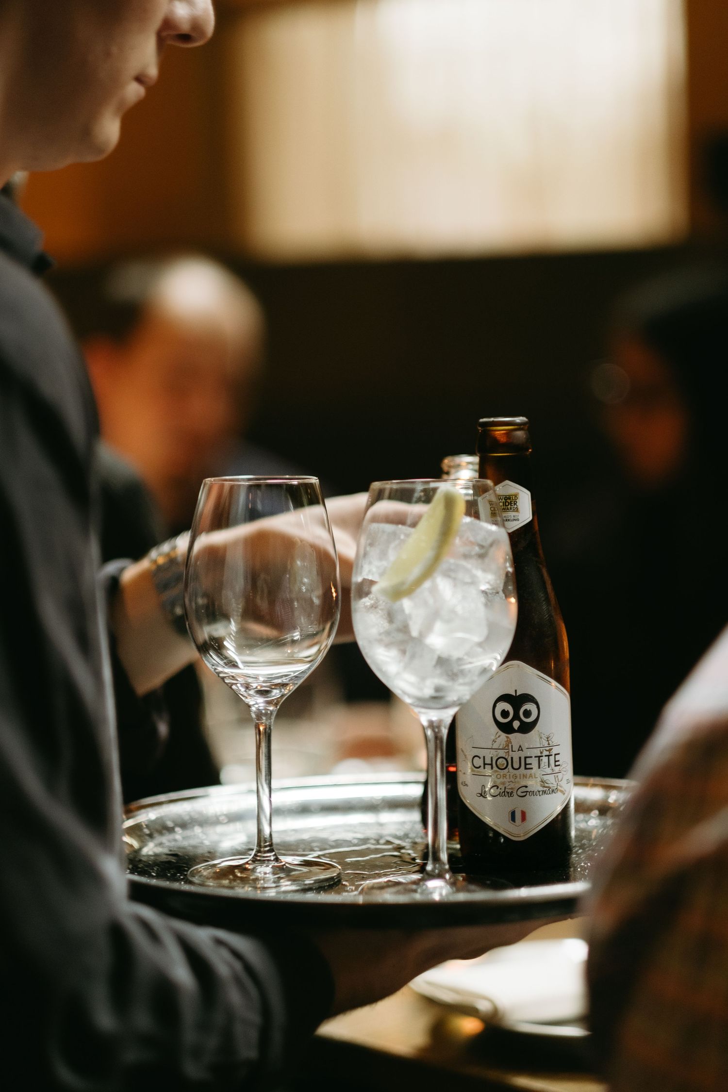 servitören tar med drinkar till ett bord i restaurangen medan han blir fångad av livsstilsfotograf i Stockholm