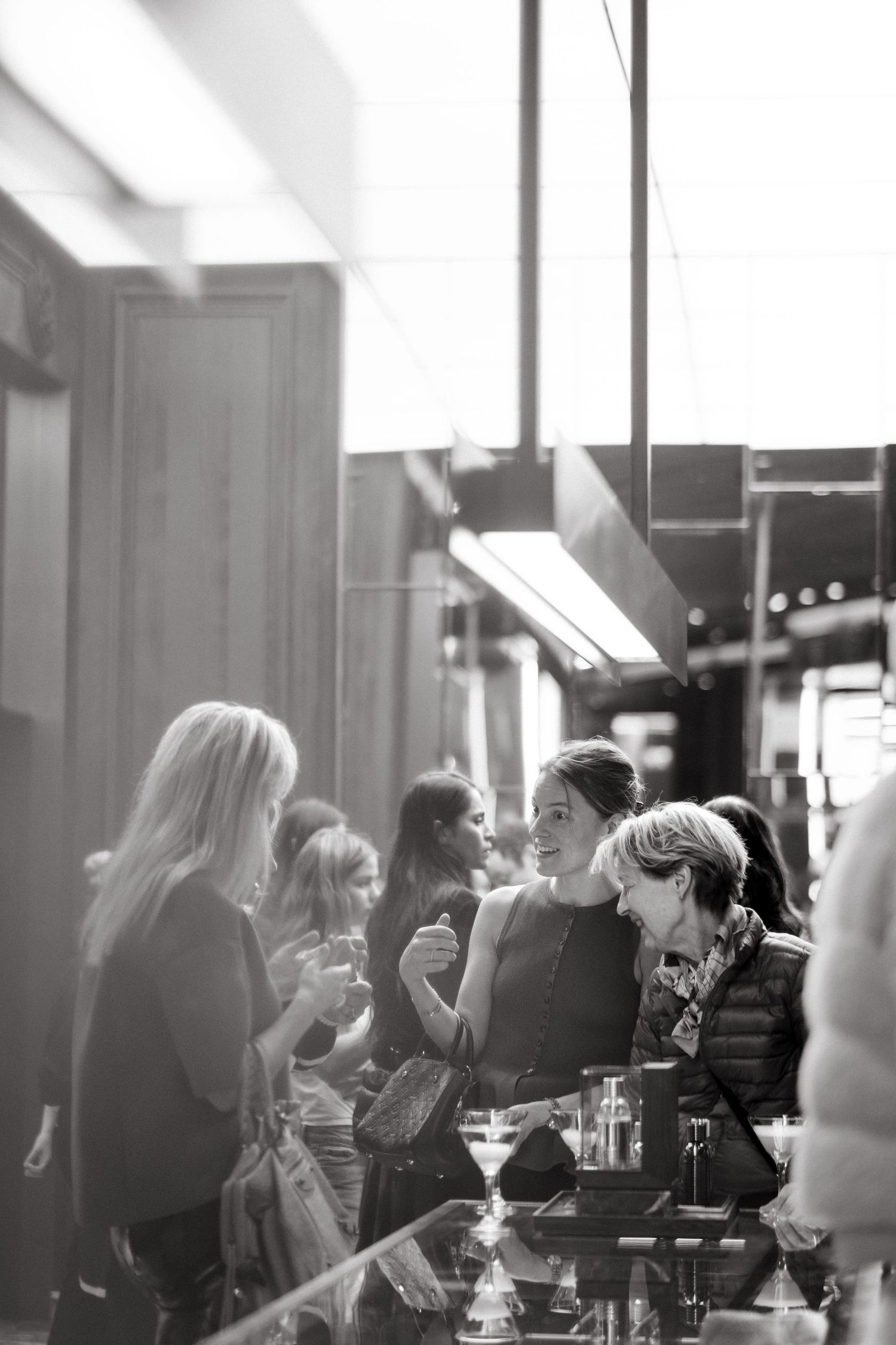 women shopping and smiling at Moncler Store while being captured by English speaking professional event photographer in Stockholm