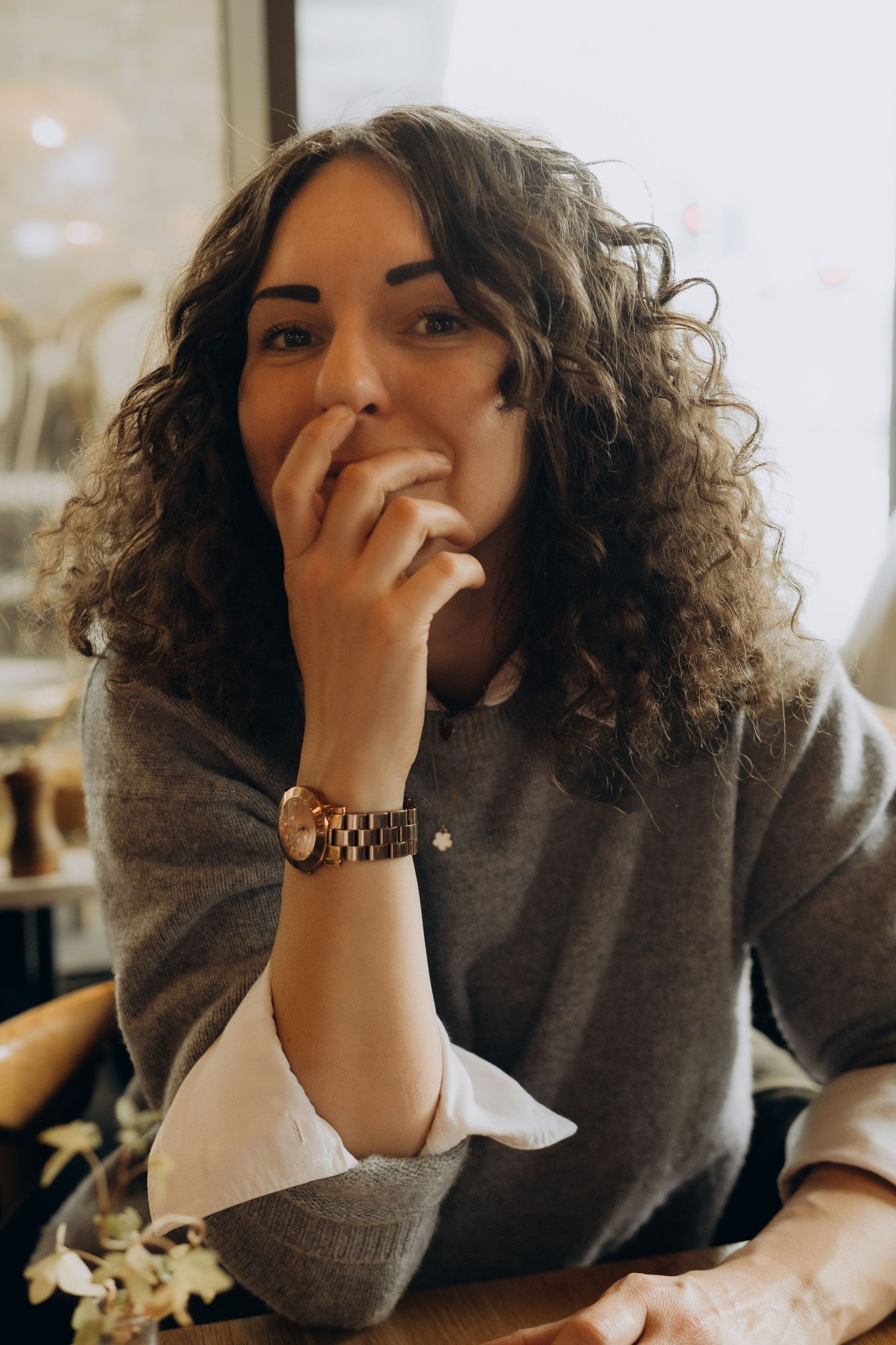 event photographer in Stockholm looking into a camera and smiling while sitting in a café