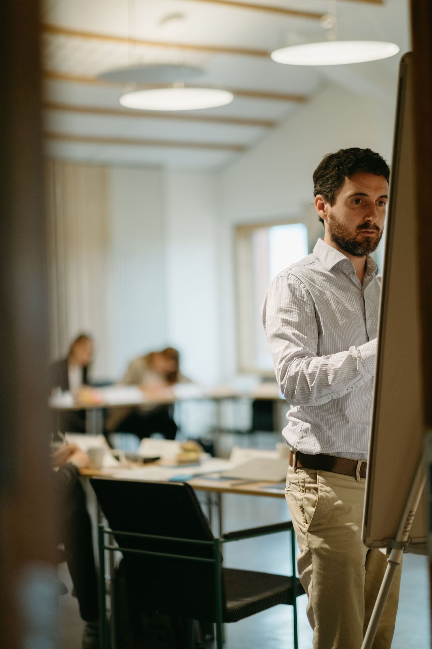 a man writing on a white board in a classroom at Stockholm University while being captured by professional event photogr