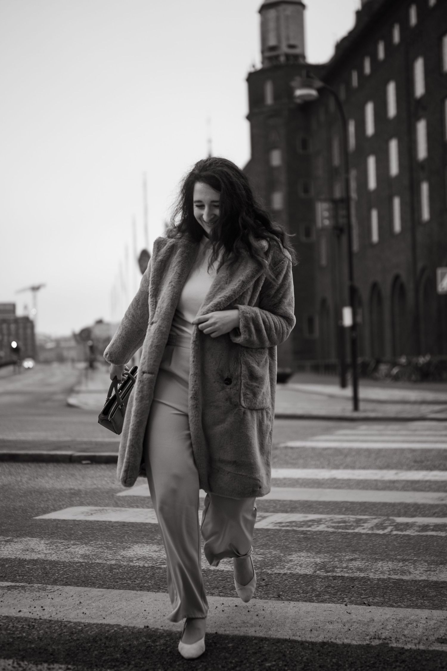 woman crossing a road in Stockholm streets while being captured by Stockholm branding portraits photographer