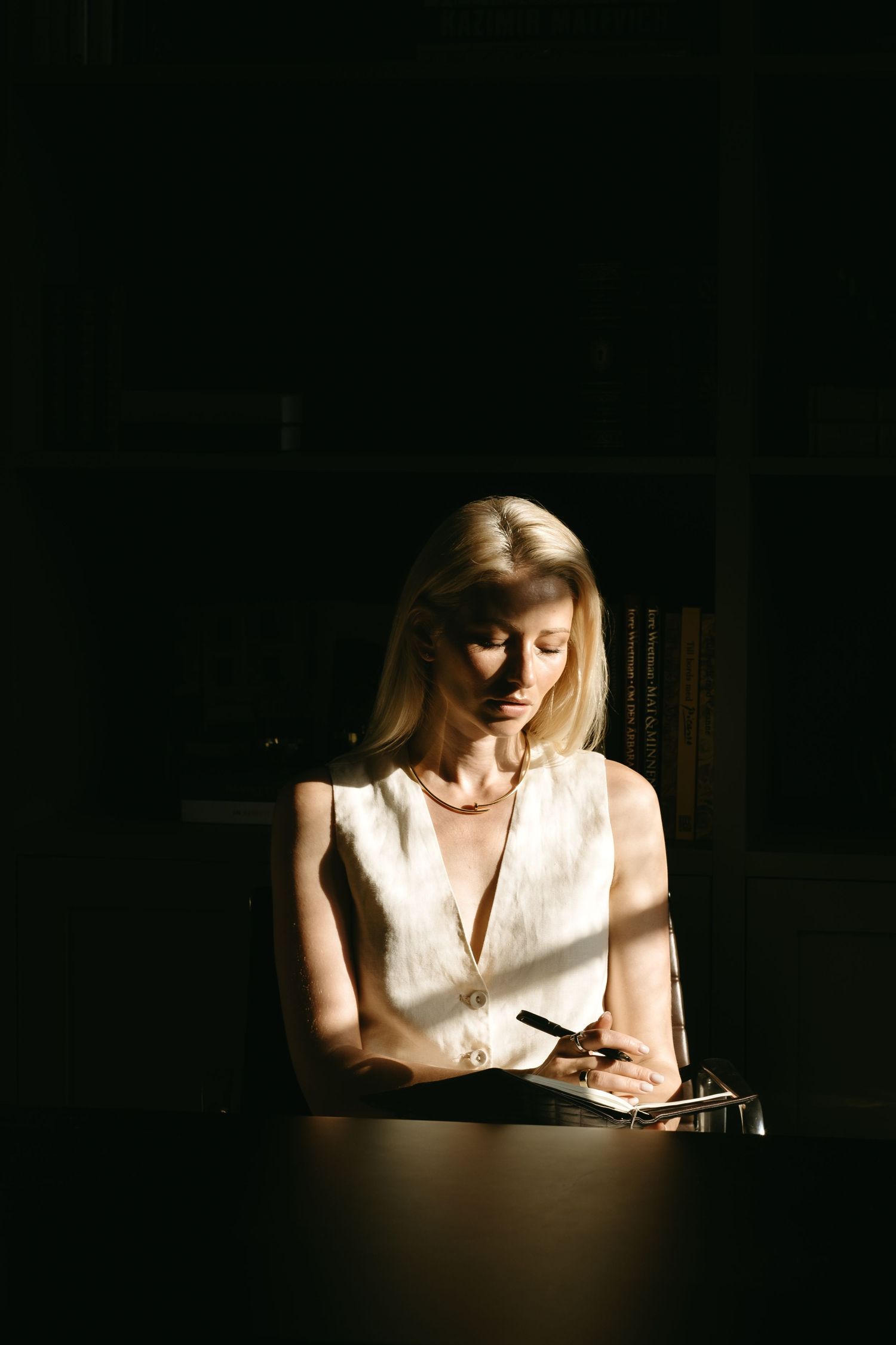 personal branding portrait of a woman illuminated by natural light in  a dark room captured by personal branding photographer in Stockholm