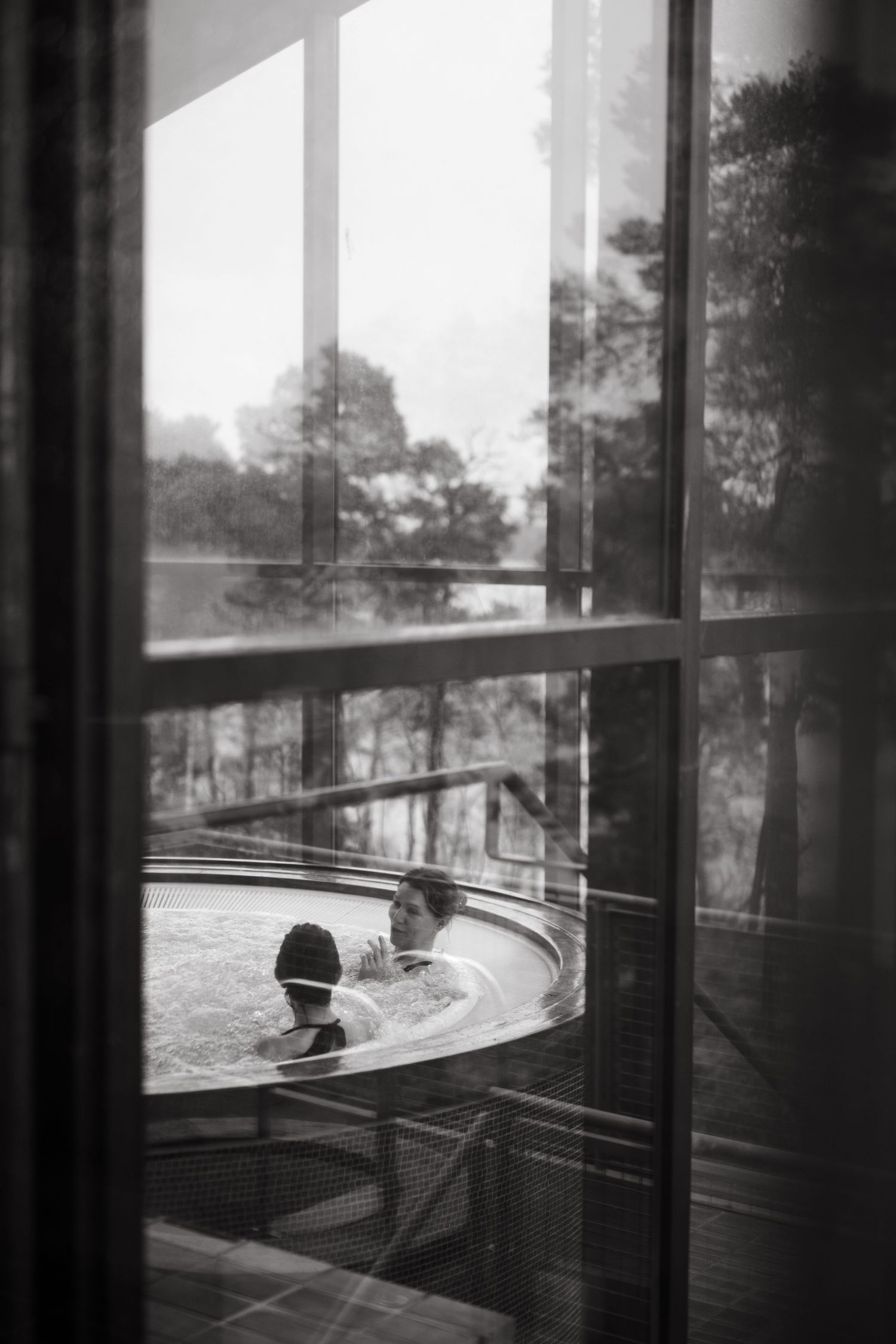 two women sitting in jacuzzi in Stockholm spa hotel while being captured by lifestyle event photographer