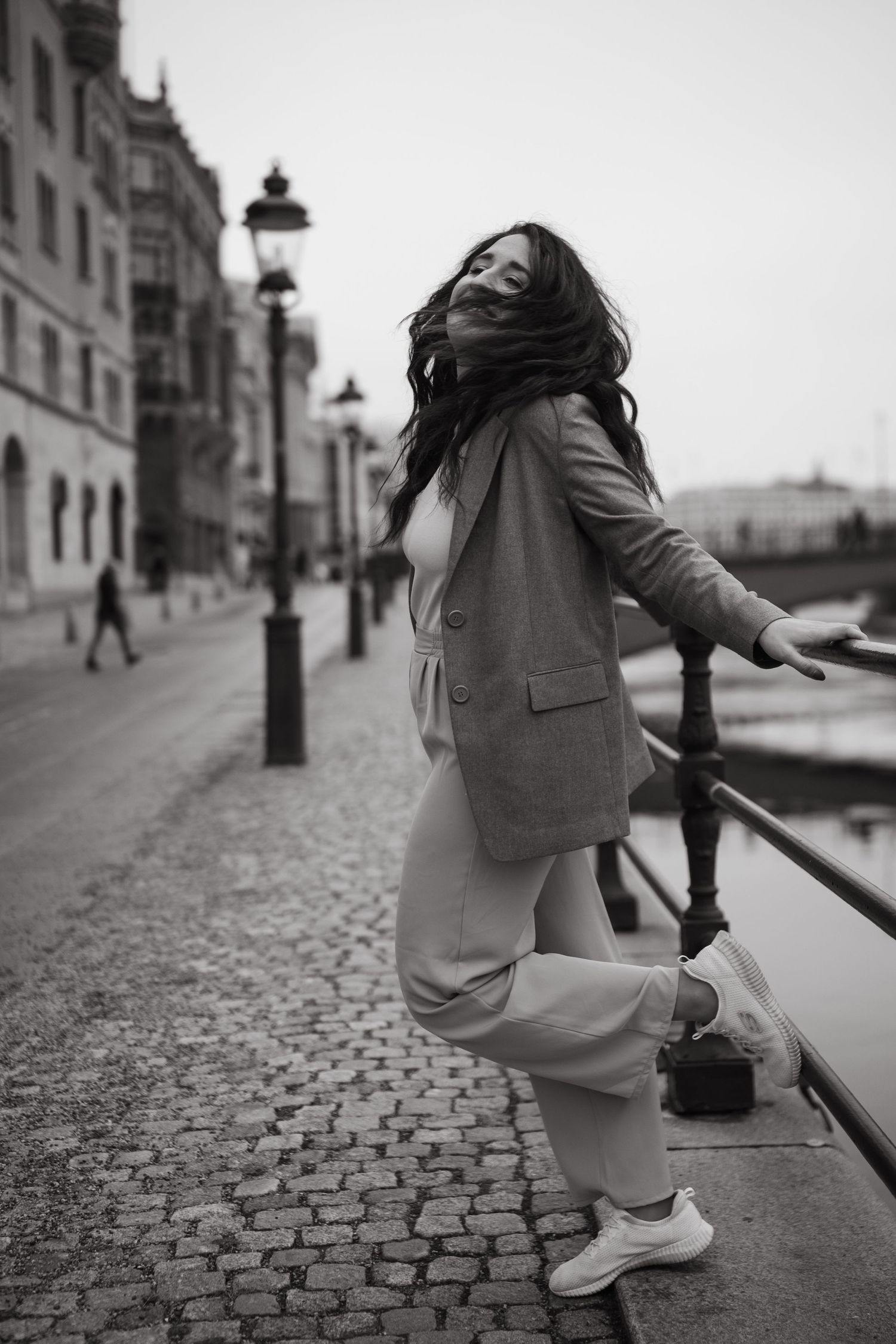a woman touching a rail in Stockholm city and looking away during personal branding photoshoot