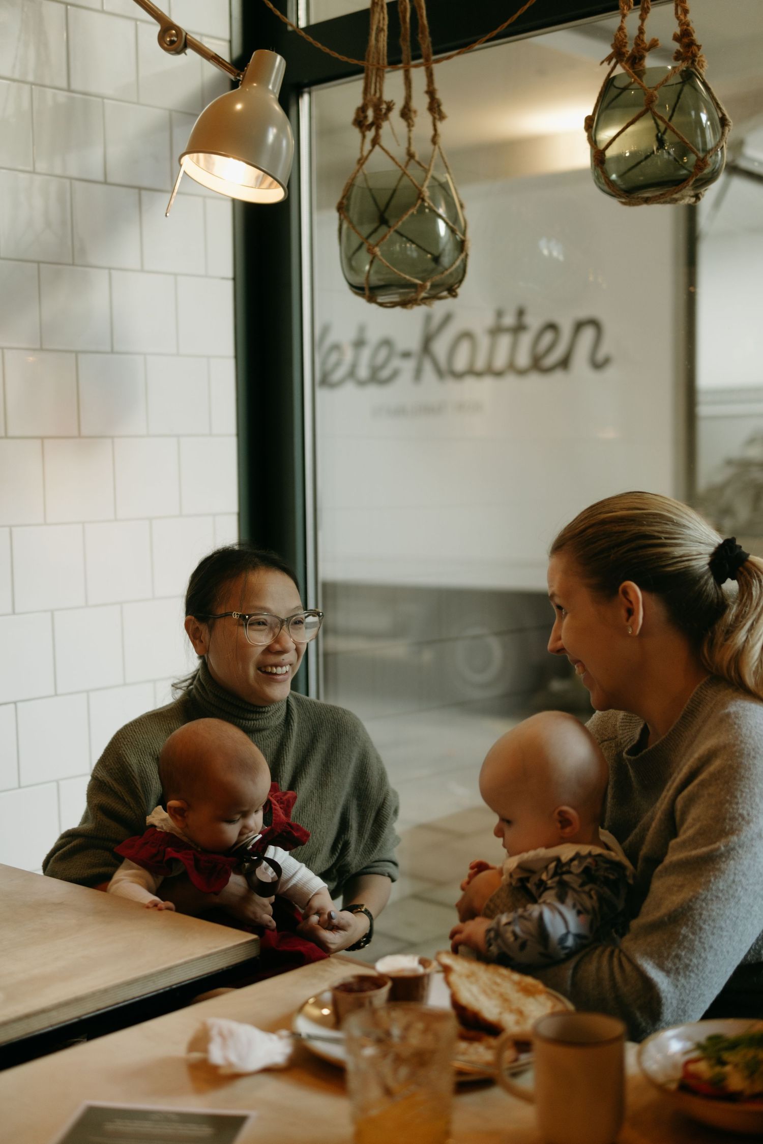 two mothers sitting with their babies in Kaferang café in Stockholm while being captured by event photographer