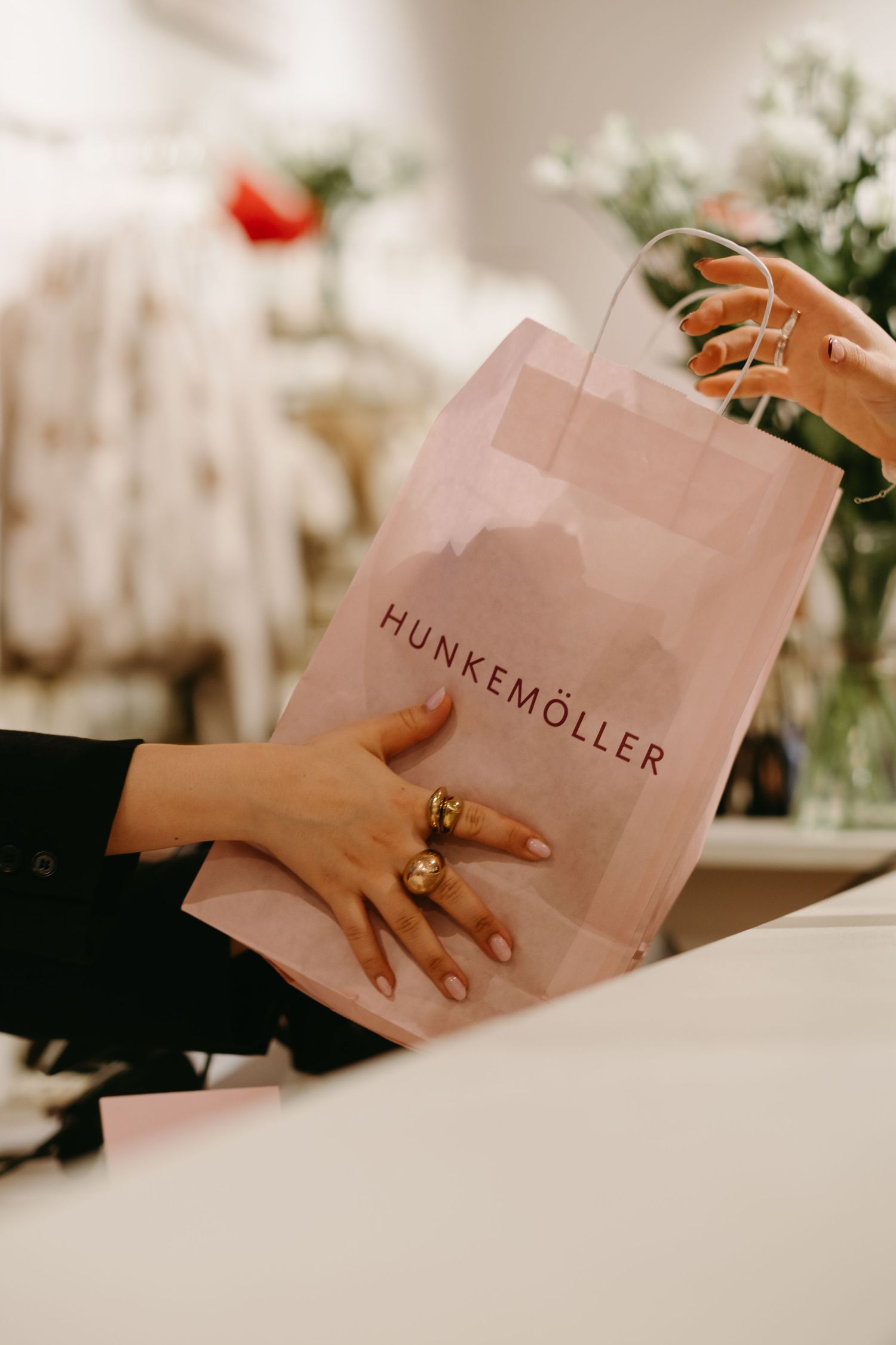 detail of a shopping bag passed between retailer and customer captured by event photographer in Stockholm for PR brand event