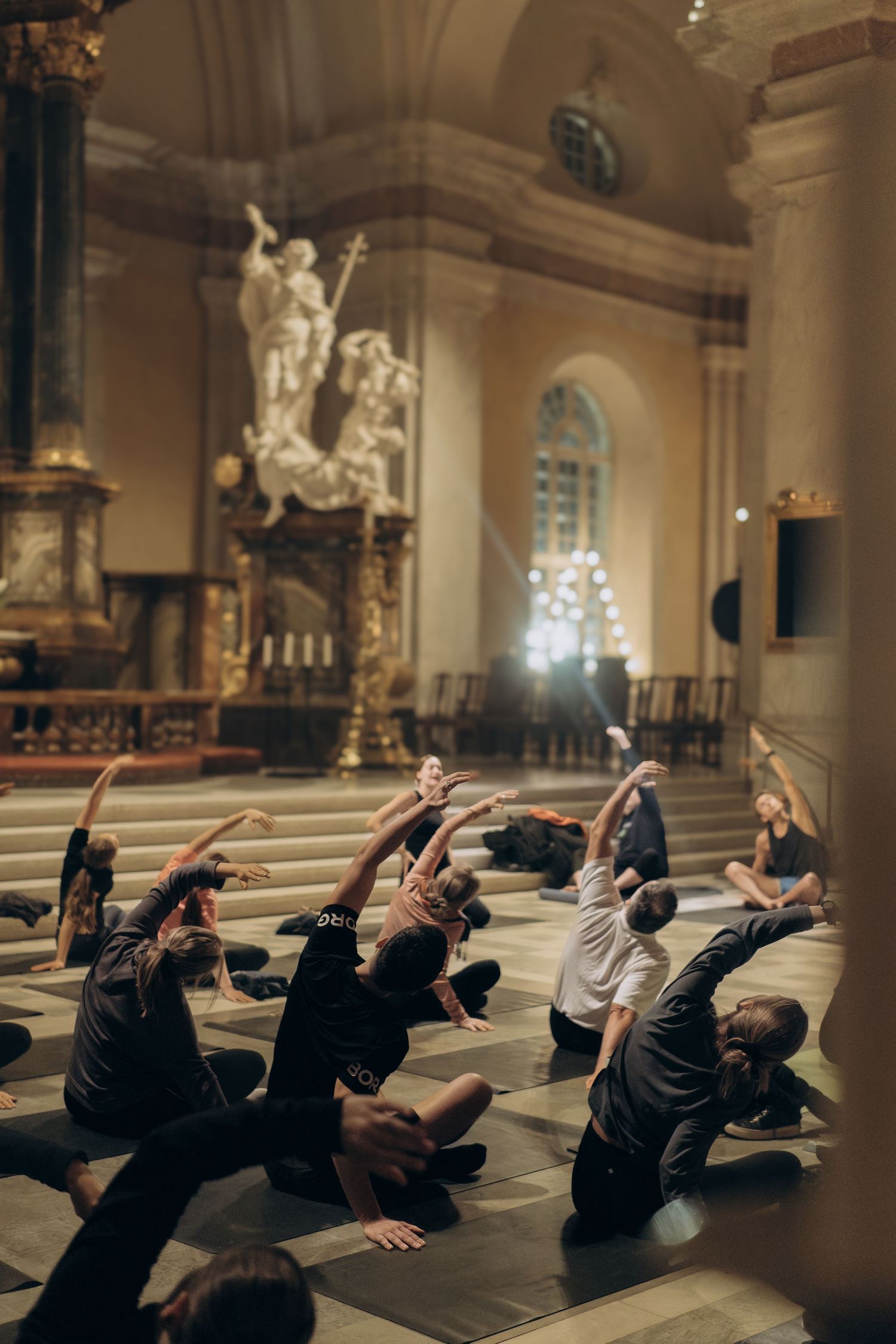 a group of people practising yoga in a church while being captured by lifestyle photographer in Stockholm