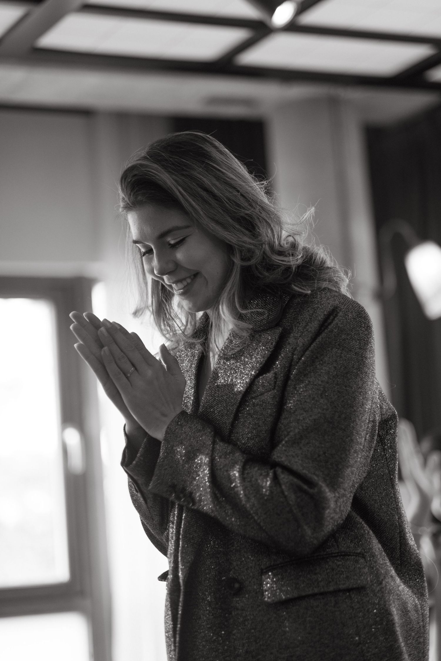female speaker laughs and claps her hands in gratitude while being captured by corporate photographer in Stockholm