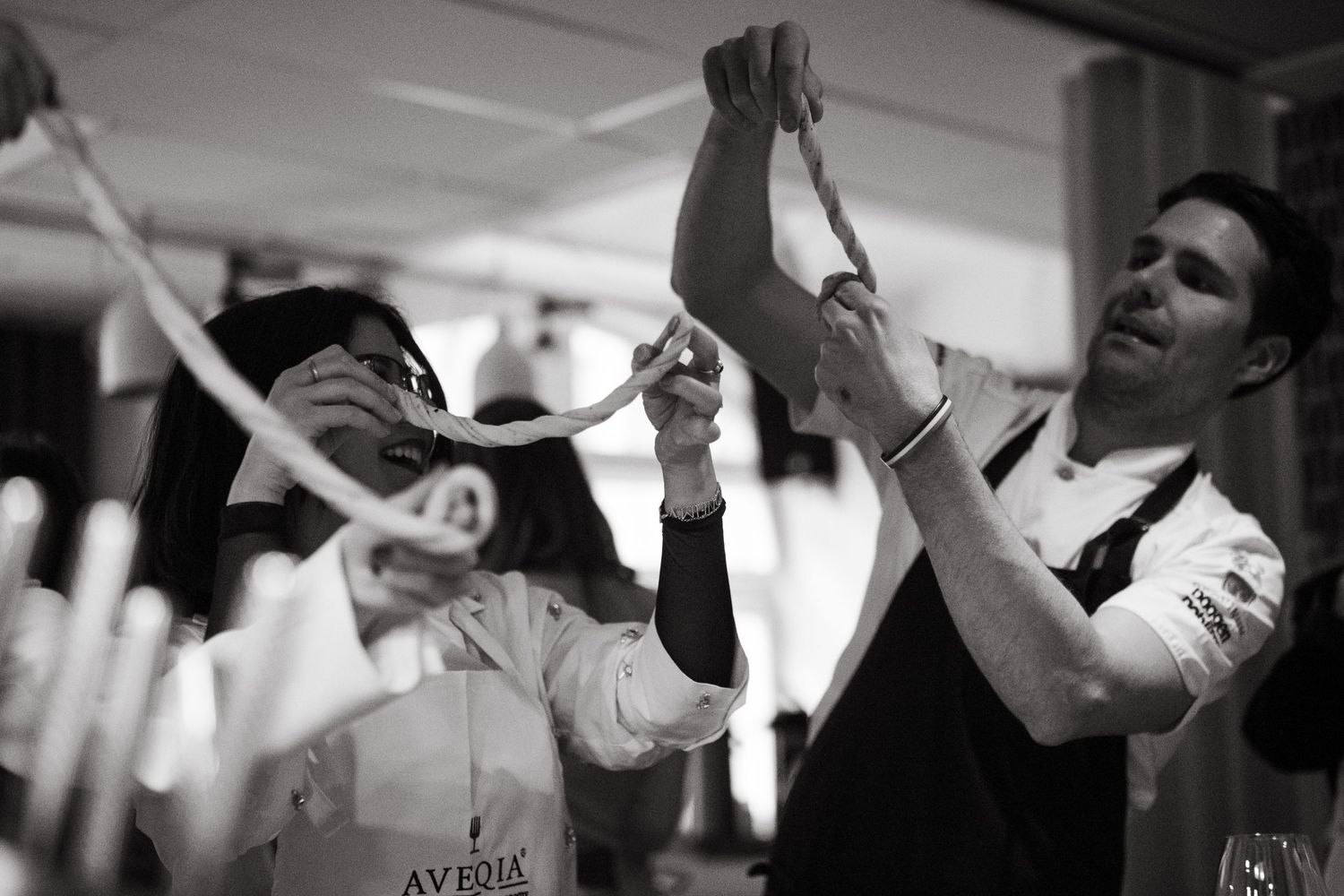 man and woman twisting dough for cinnamon buns at Aveqia in Stockholm while being captured by lifestyle event photographer in Stockholm