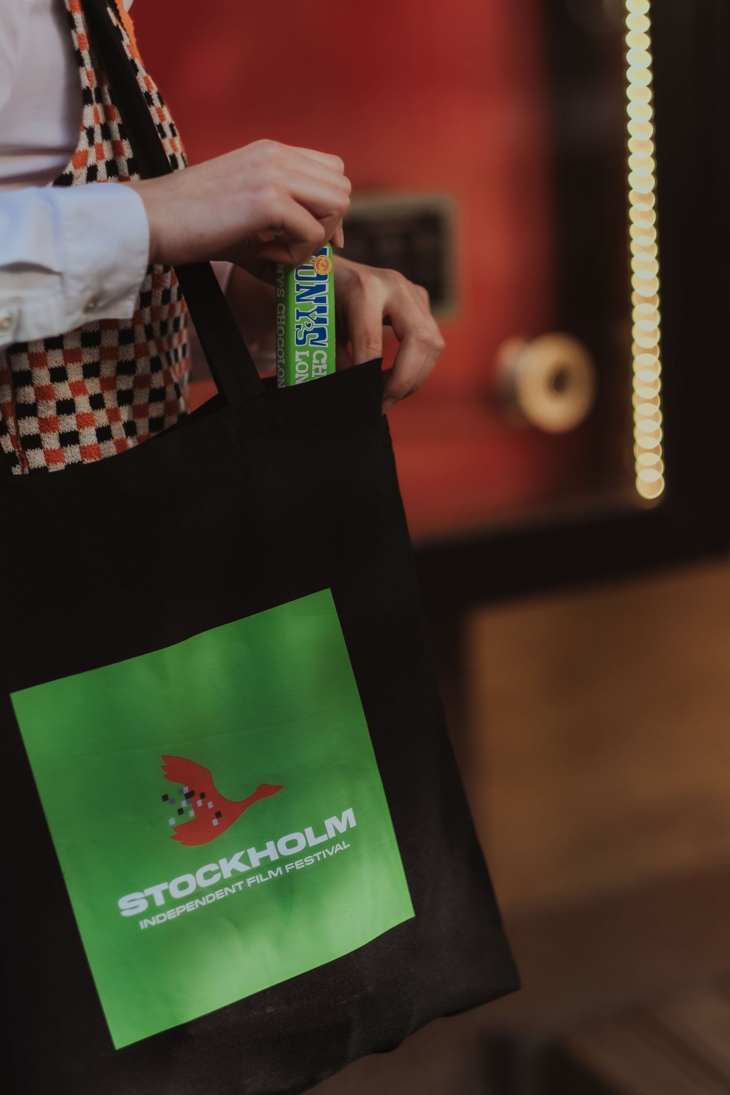 woman putting in her back a chocolate bar while being captured by brand photographer in Stockholm