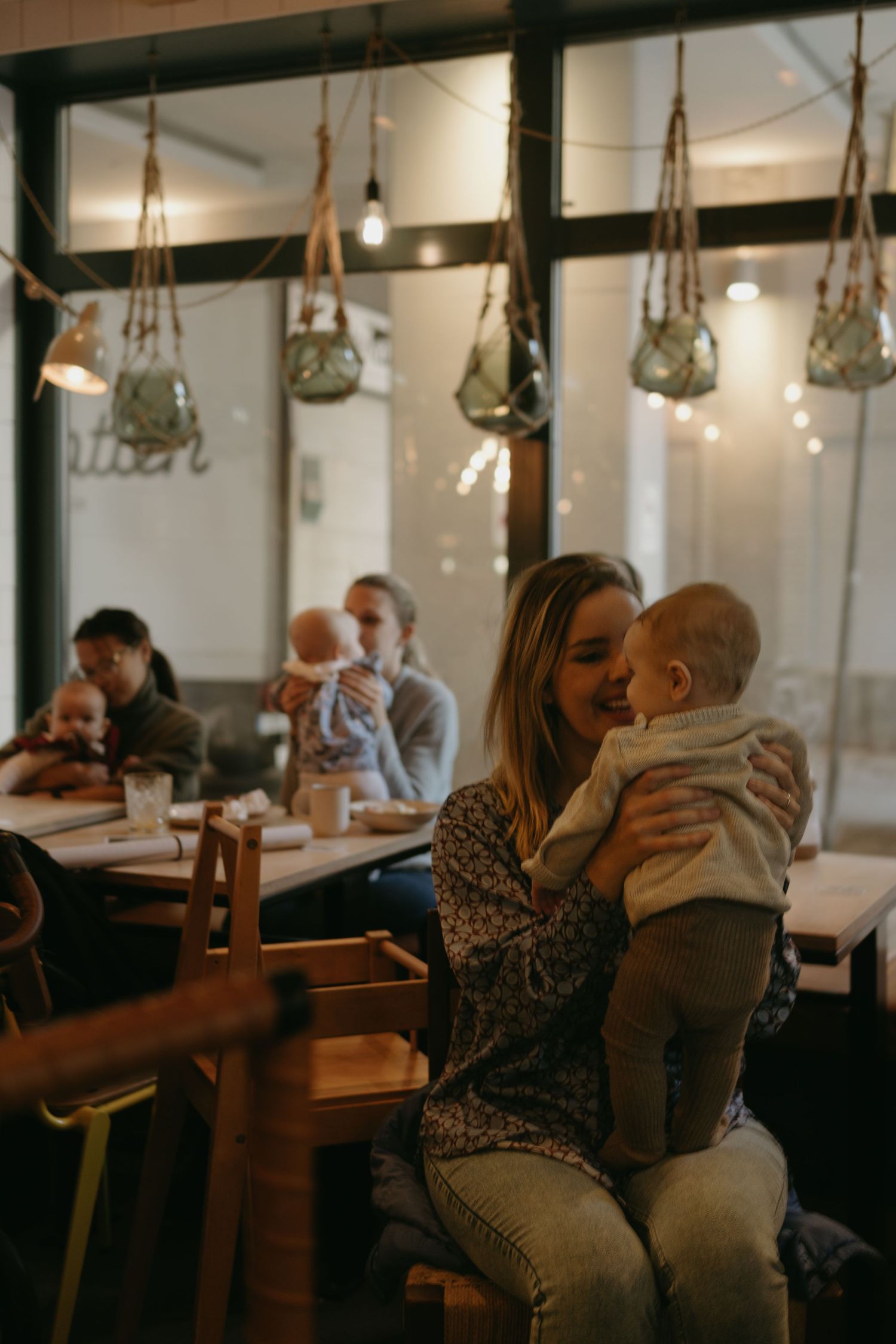 a mom is hugging her baby during networking event while being captured by business photographer in Stockholm