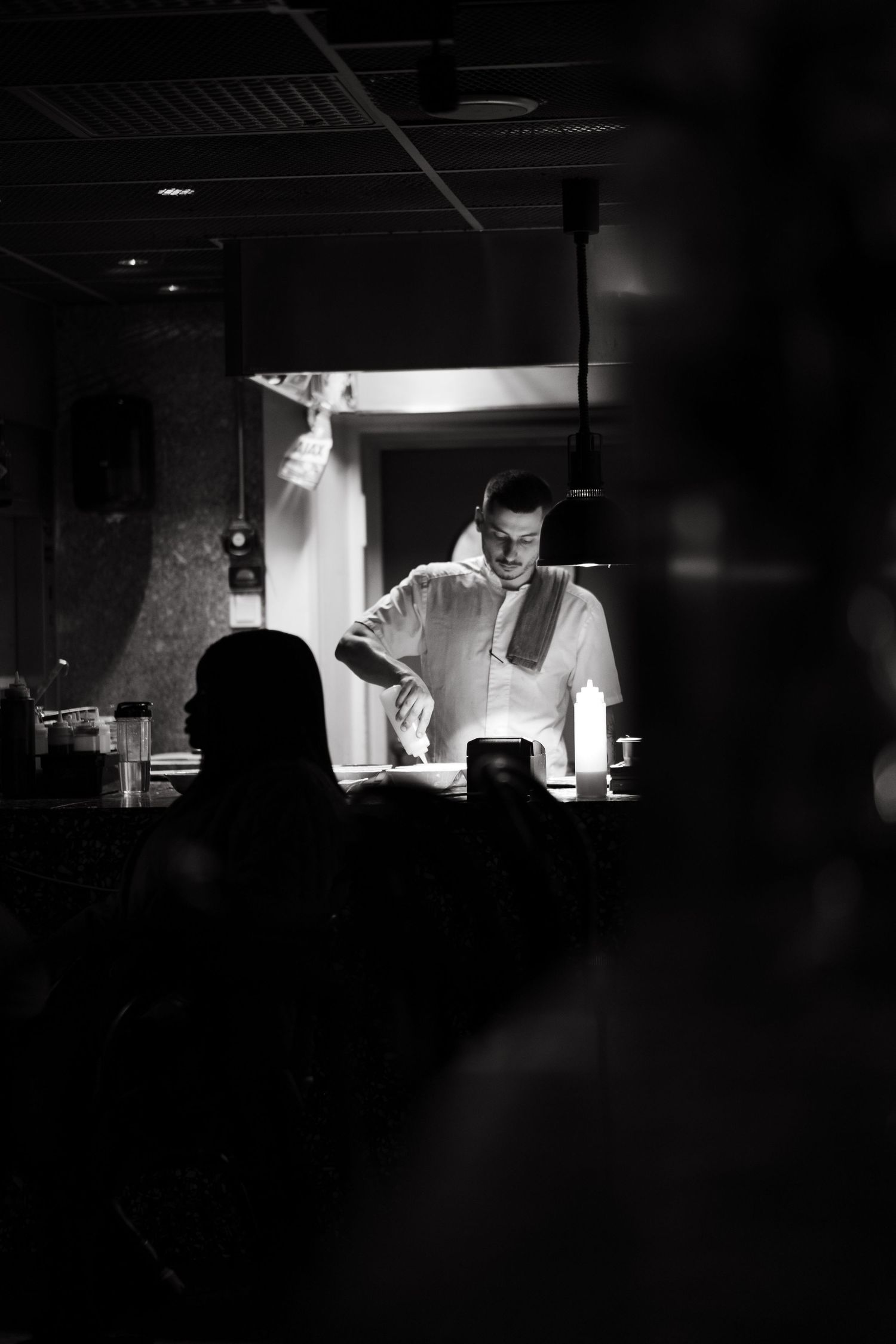 a chef preparing food in a restaurant while being captured by lifestyle photographer in Stockholm