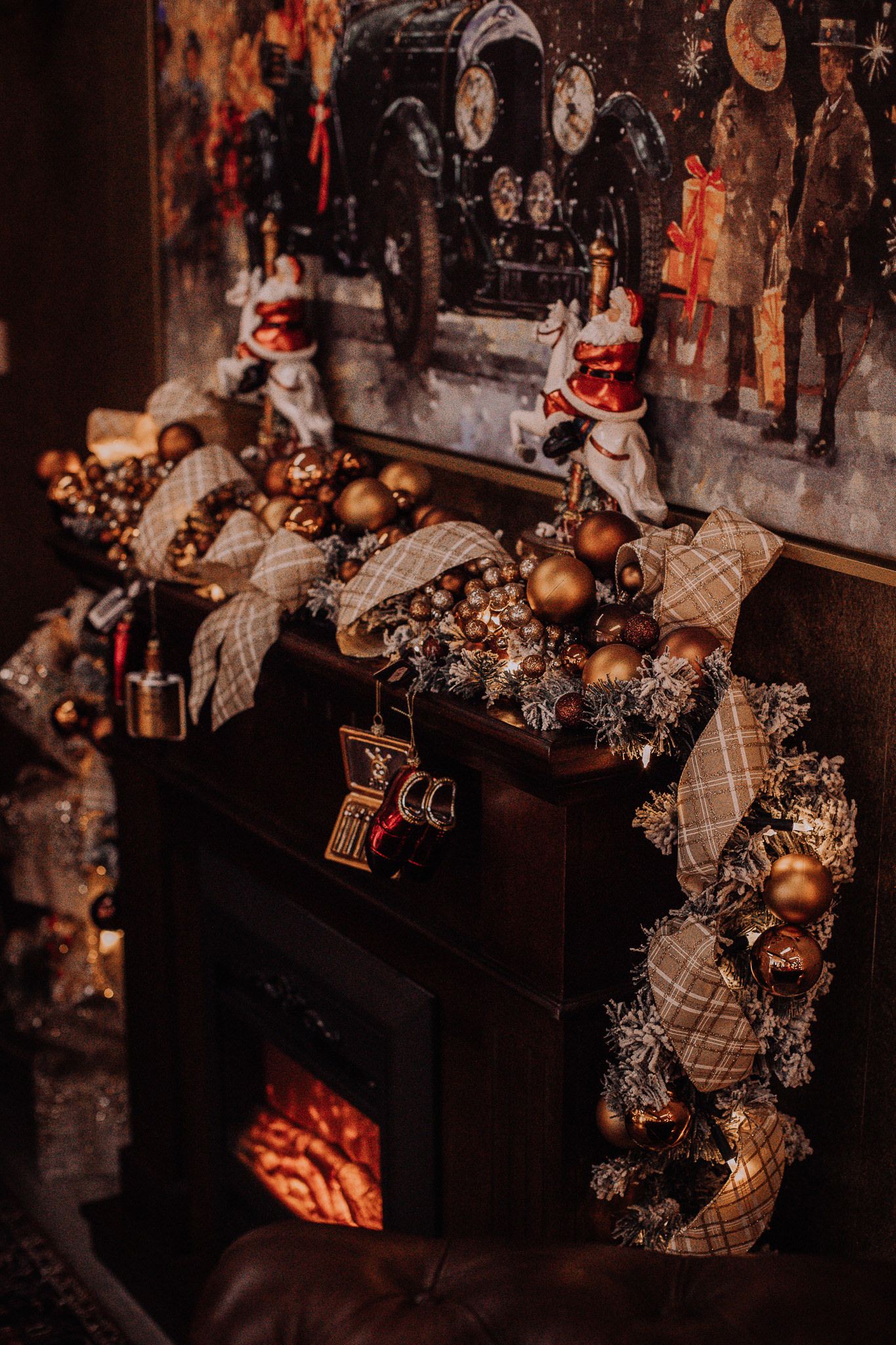 A rustic fireplace mantel decorated with golden ornaments and Christmas garland.