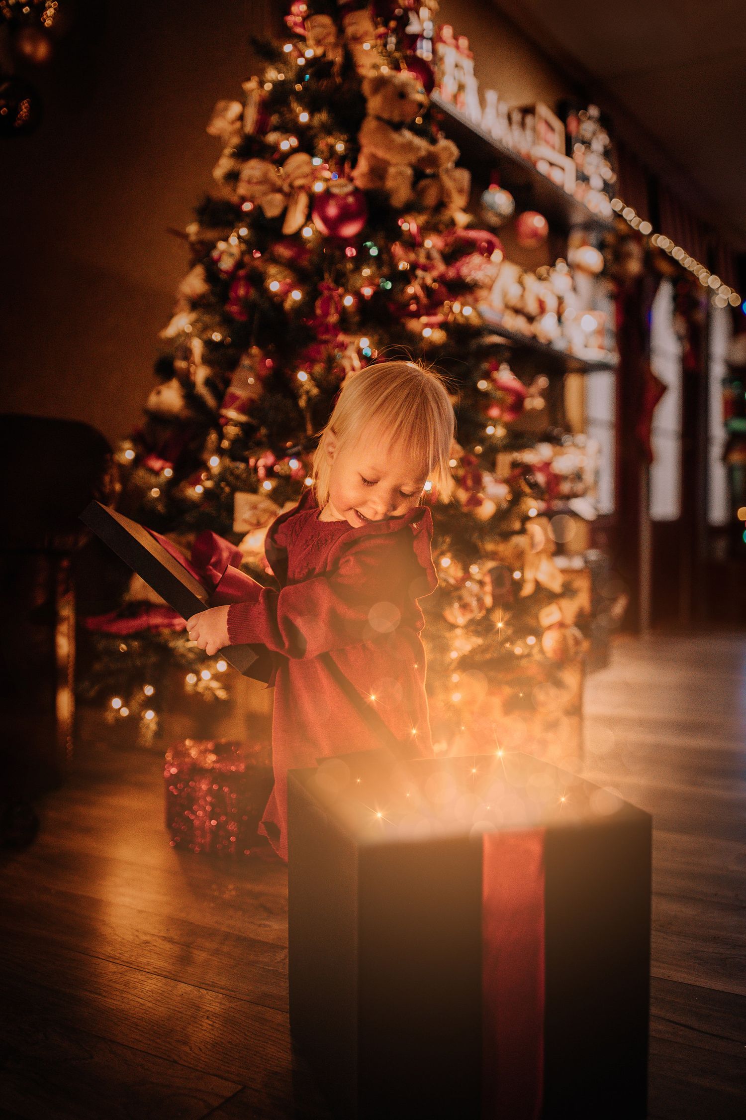 A magical moment captured as a glowing Christmas present box illuminates a decorated tree.
