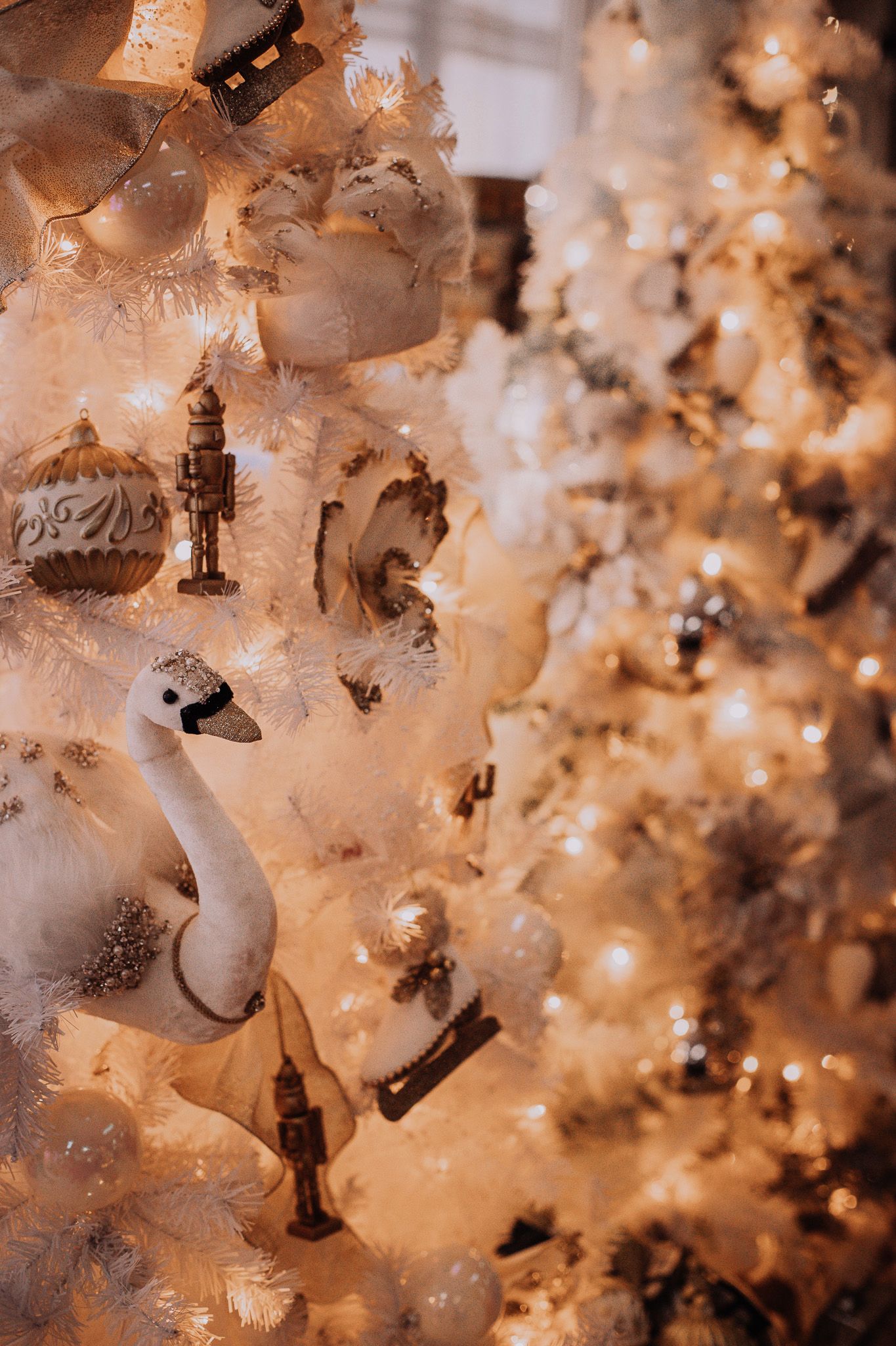 White frosted Christmas ornaments and decorations glowing with warm light create a magical holiday atmosphere.