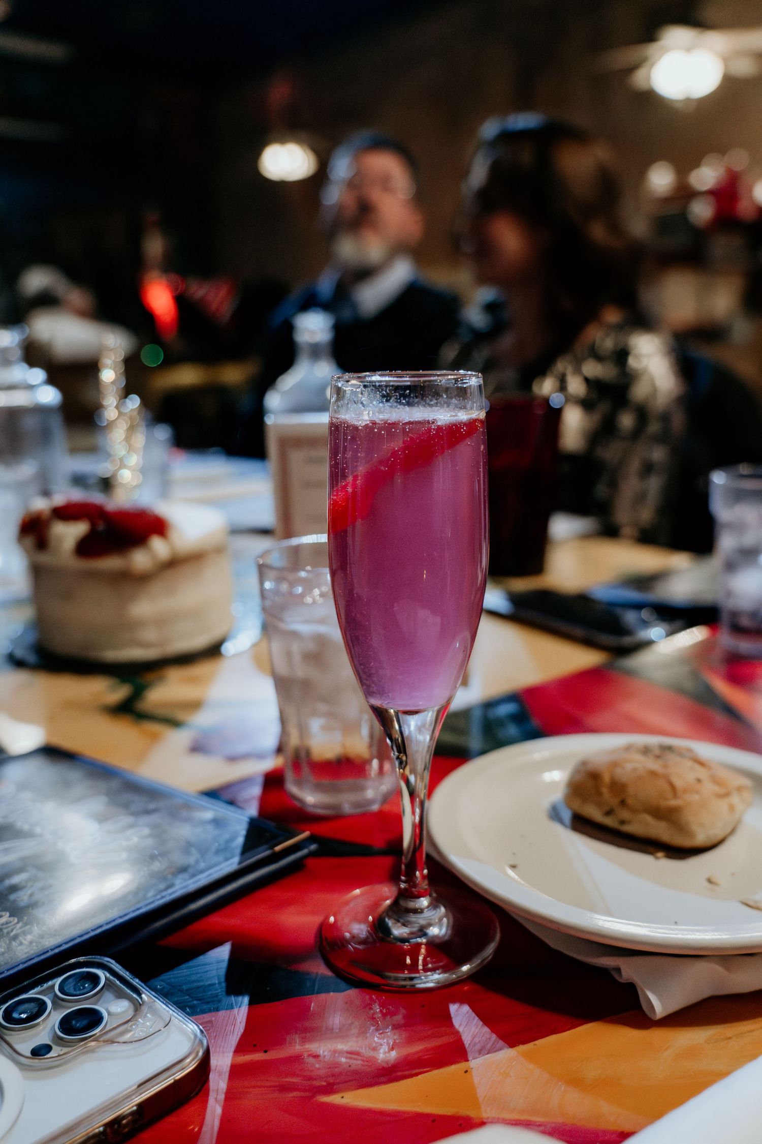 Table setting with pink cocktails and plates at a wedding reception.