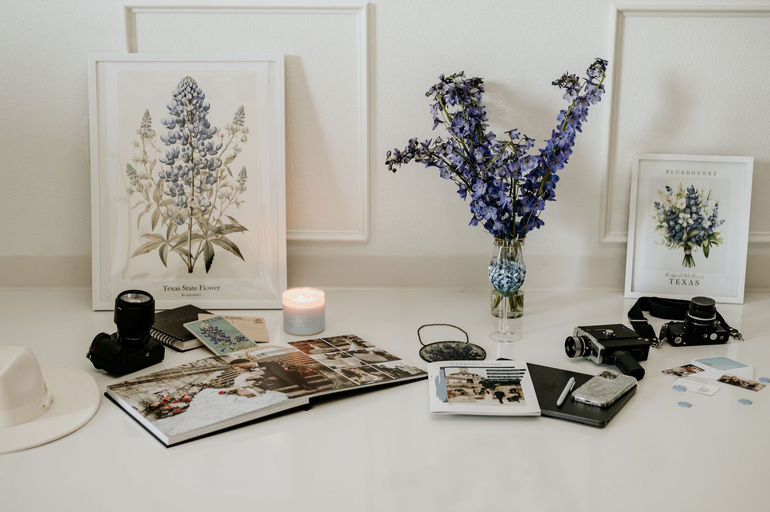 Minimalist wall decor with botanical prints and blue flowers in a bright white room.