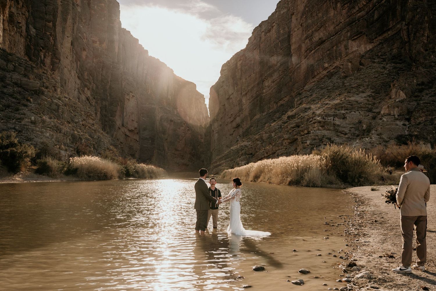 Dramatic canyon walls frame a river scene with sunlight streaming through the gorge.