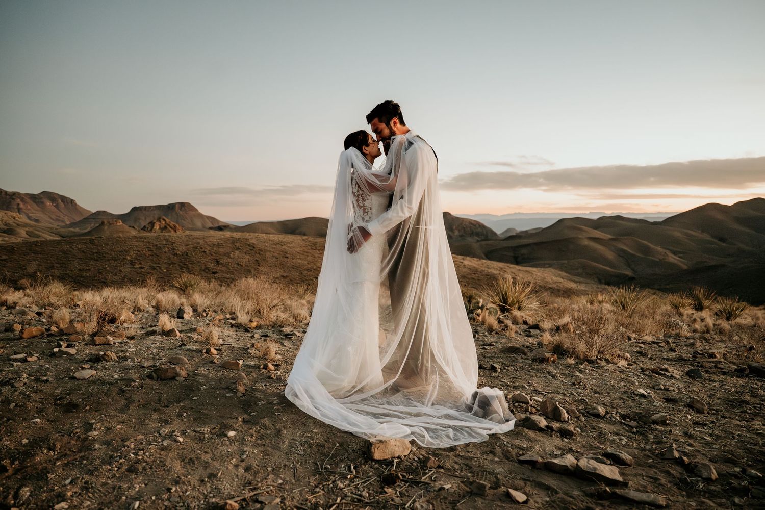Desert mountain wedding portraits with dramatic evening light.