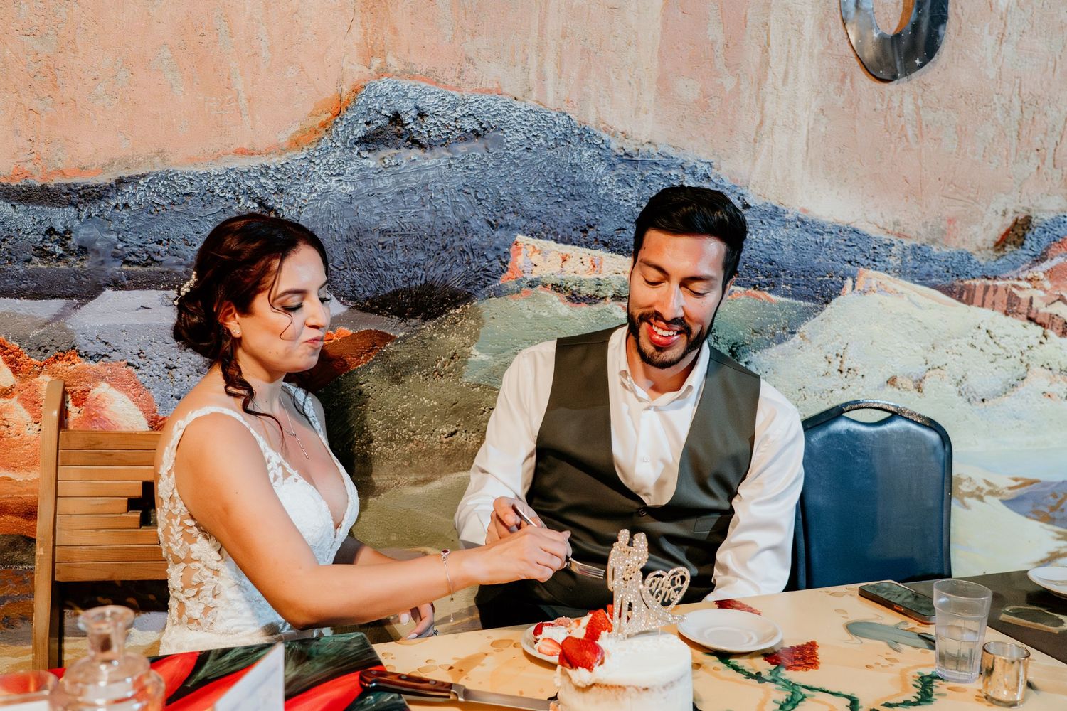 Wedding reception table setting with cake and decorative elements in warm lighting.