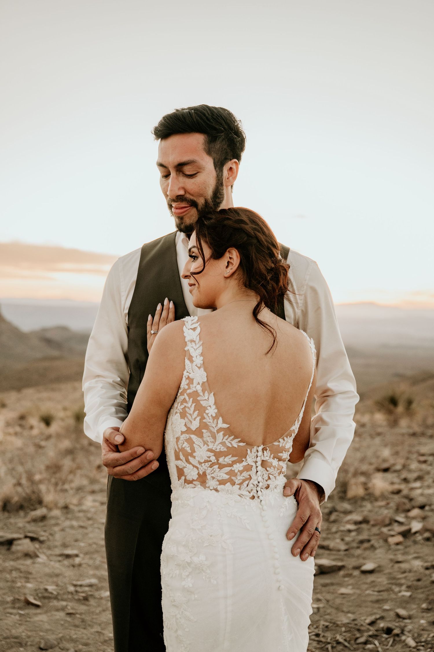 Intimate wedding portraits captured against desert mountains during golden hour.
