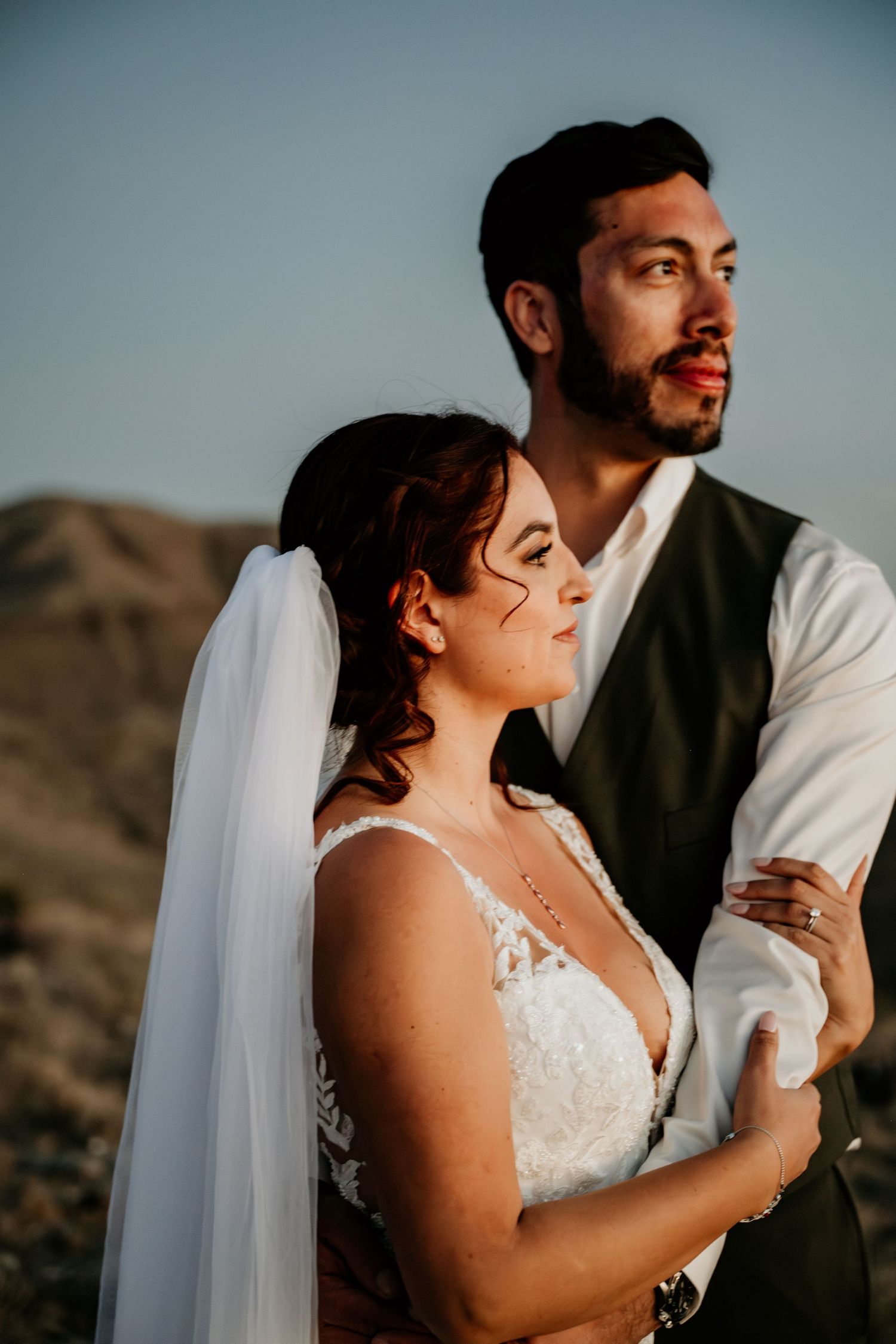 Close-up wedding portrait against desert mountain backdrop.