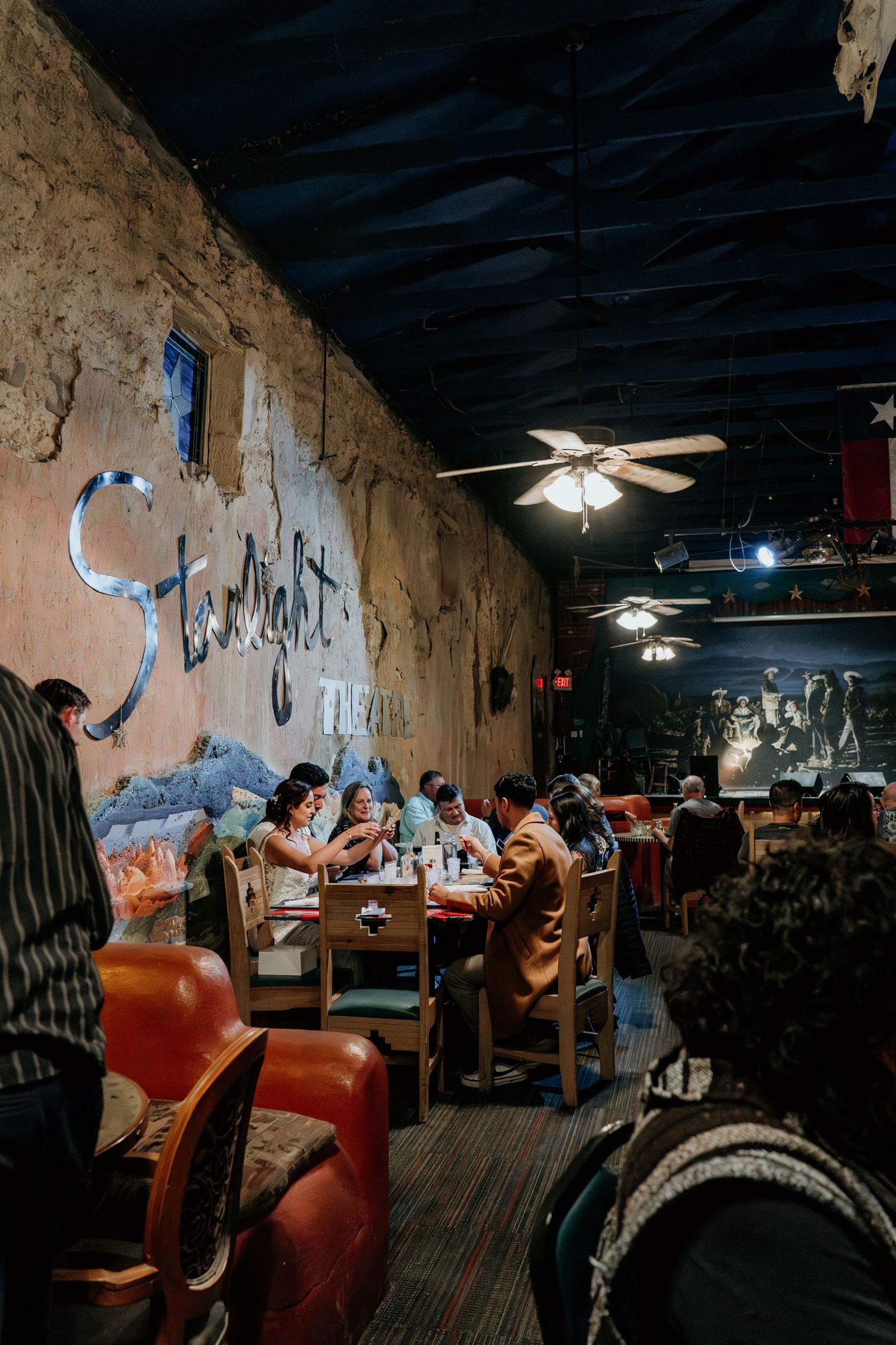 Rustic restaurant interior with painted walls and leather booth seating.