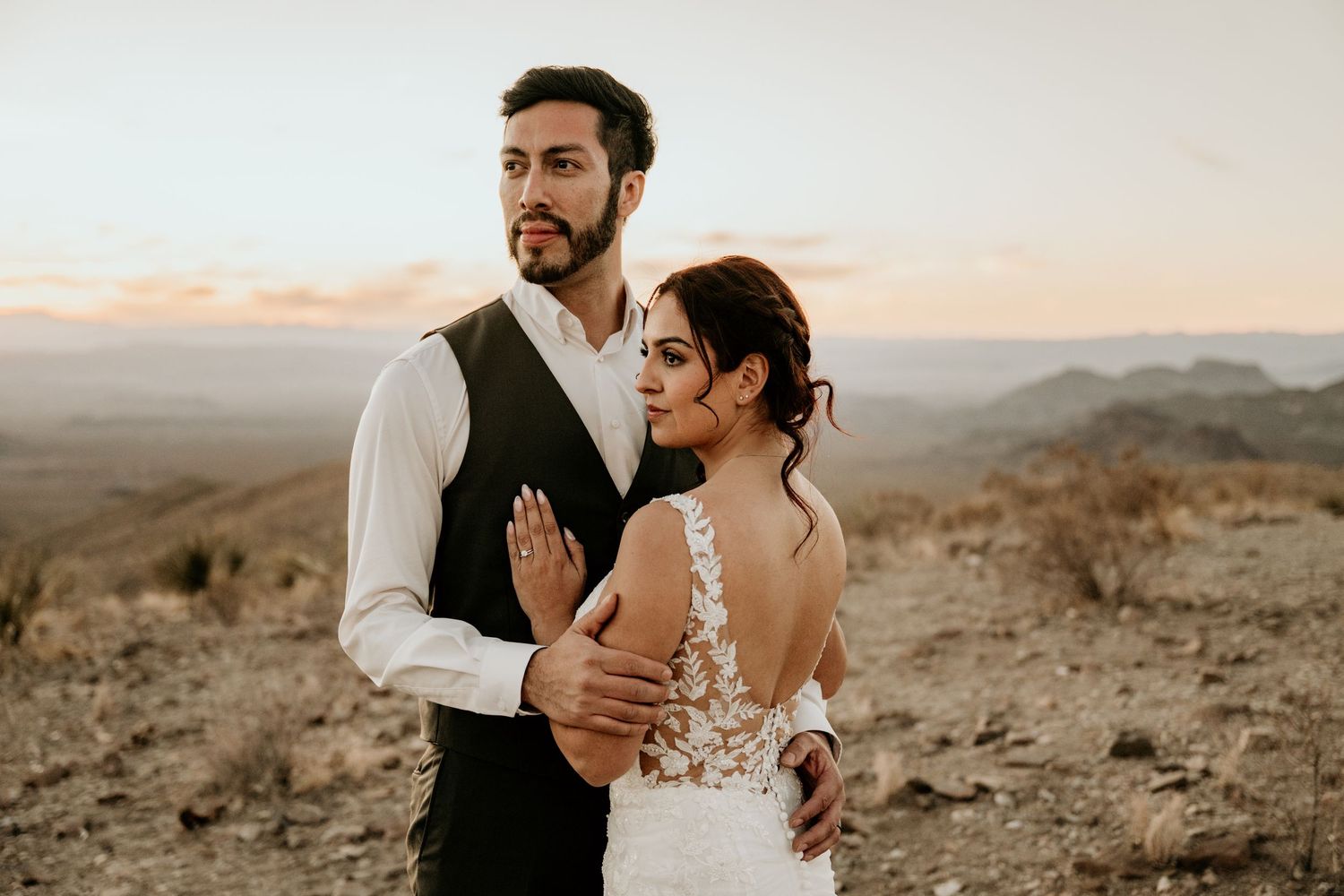 Wedding couple shares intimate moments on a desert mountaintop during golden hour.