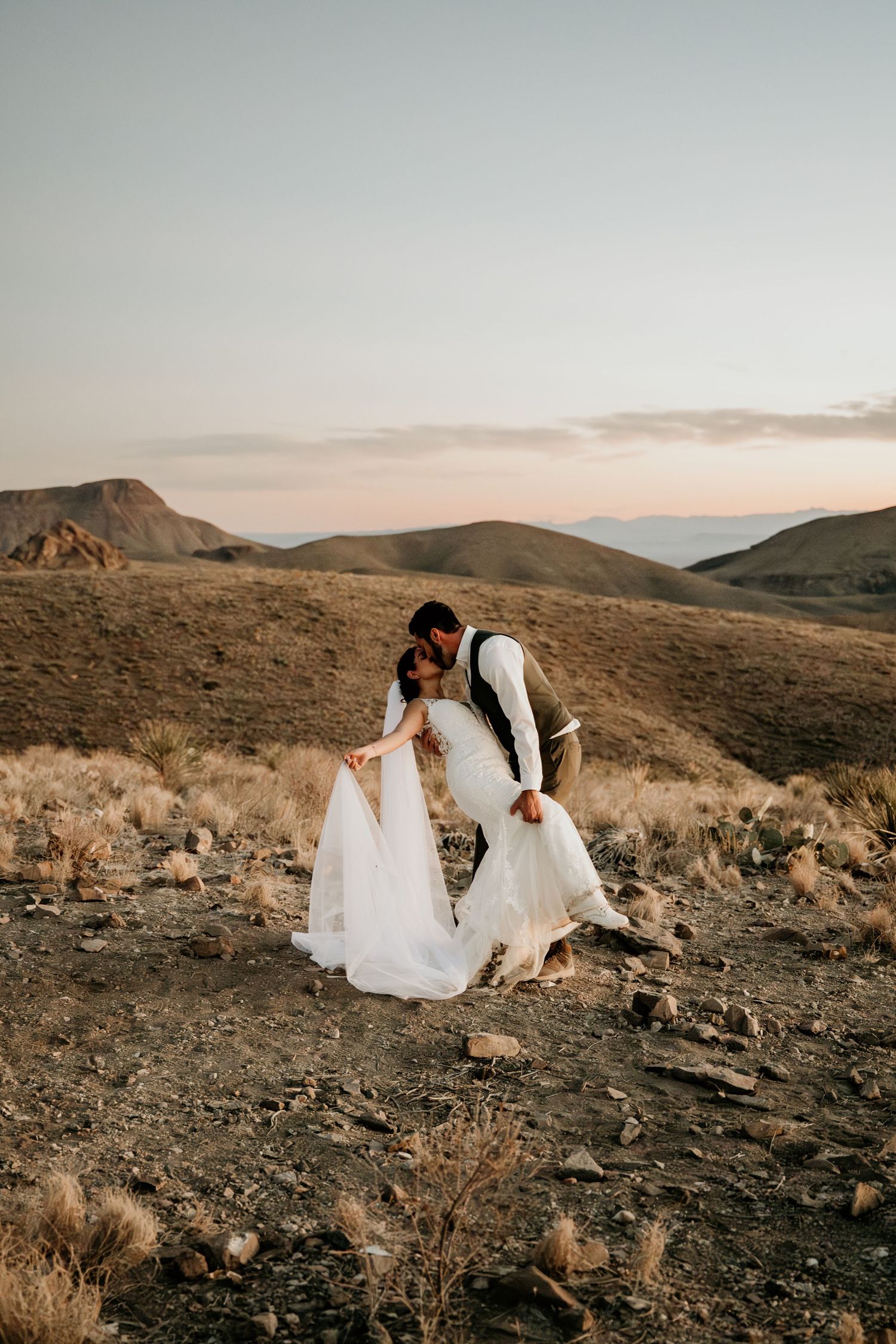 Wedding photography session in rugged desert mountain terrain at sunset.