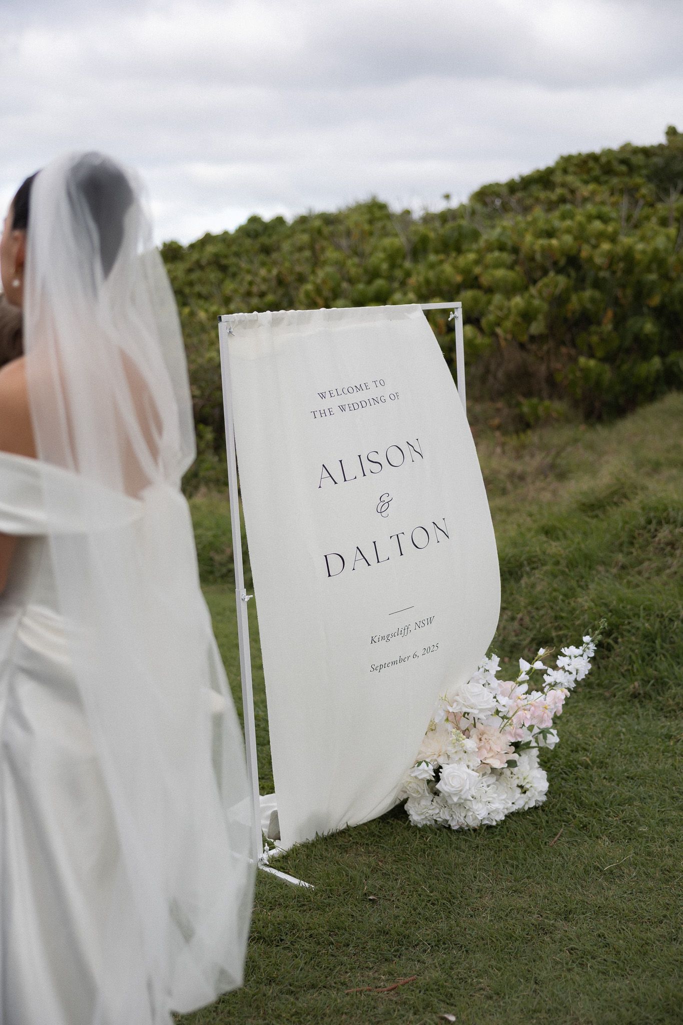 Elegant wedding welcome sign for Alison and Dalton with floral arrangement at outdoor venue.