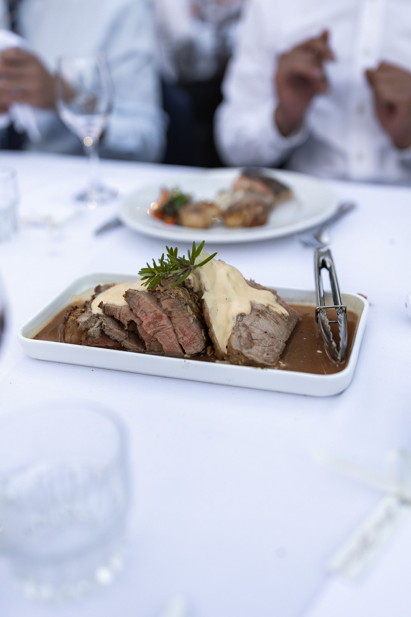 Elegant wedding reception dinner plate featuring sliced roast beef with mashed potatoes and rich gravy.