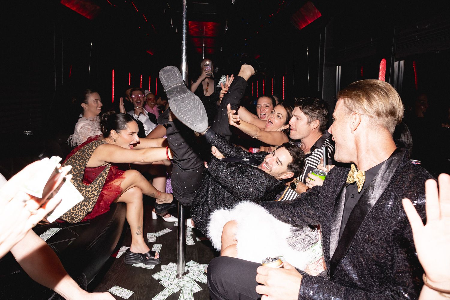 Party guests dance and celebrate inside a limo with a pole during a wild Las Vegas night out.