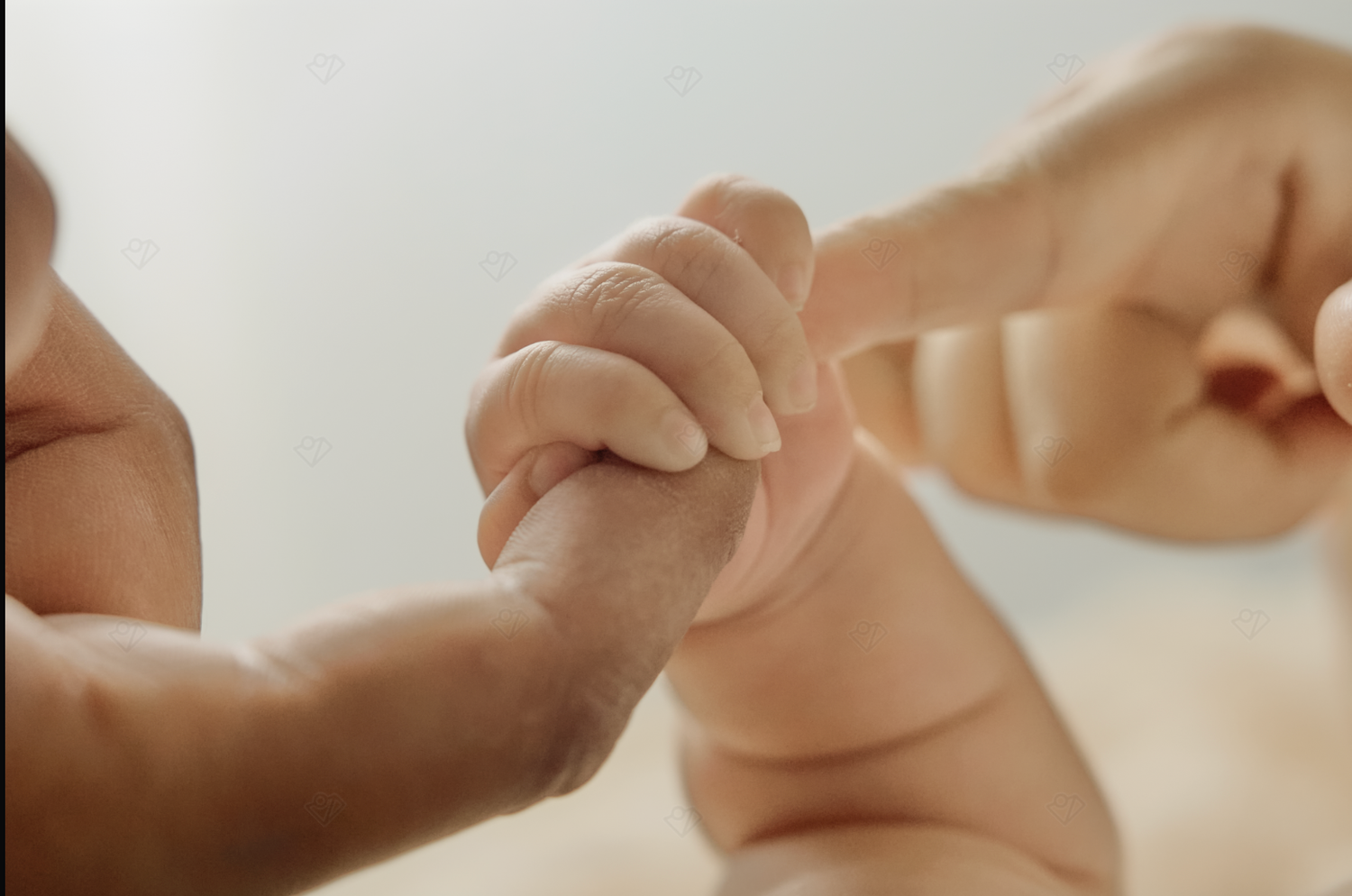 Newborn baby grasping adult finger in tender close-up, symbolizing new life, parental bond, and infant development.