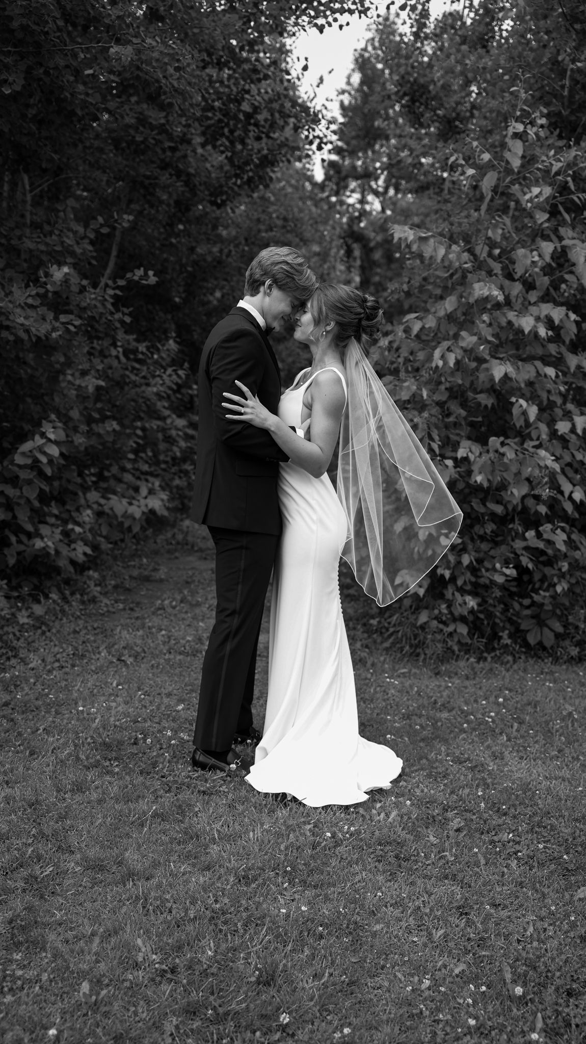 Wedding couple embracing outdoors in black and white photography sequence.