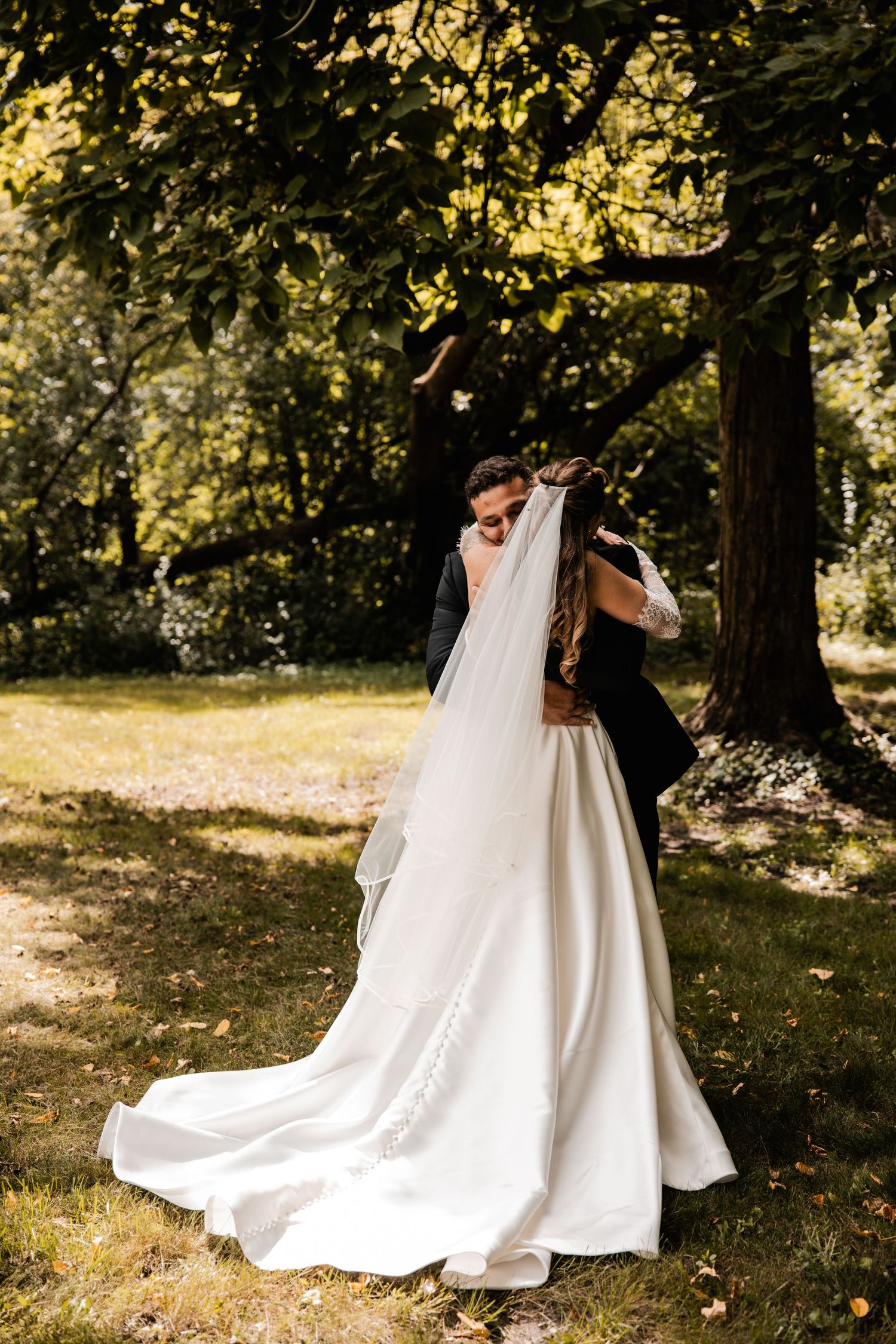 Series of romantic wedding portraits showing the flowing train of a white wedding dress in a forest setting.