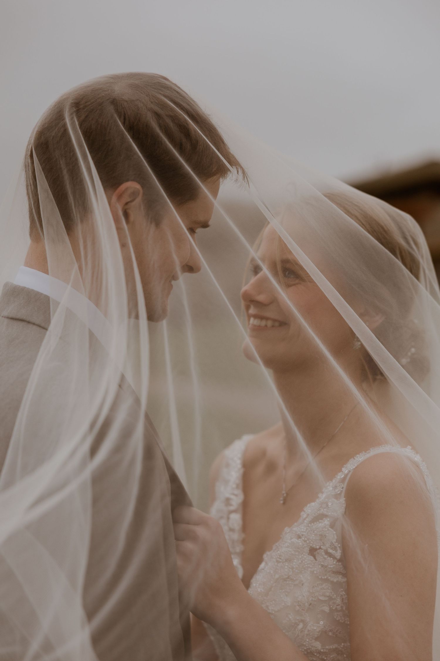 Ethereal wedding scene with delicate veil creating soft romantic atmosphere.