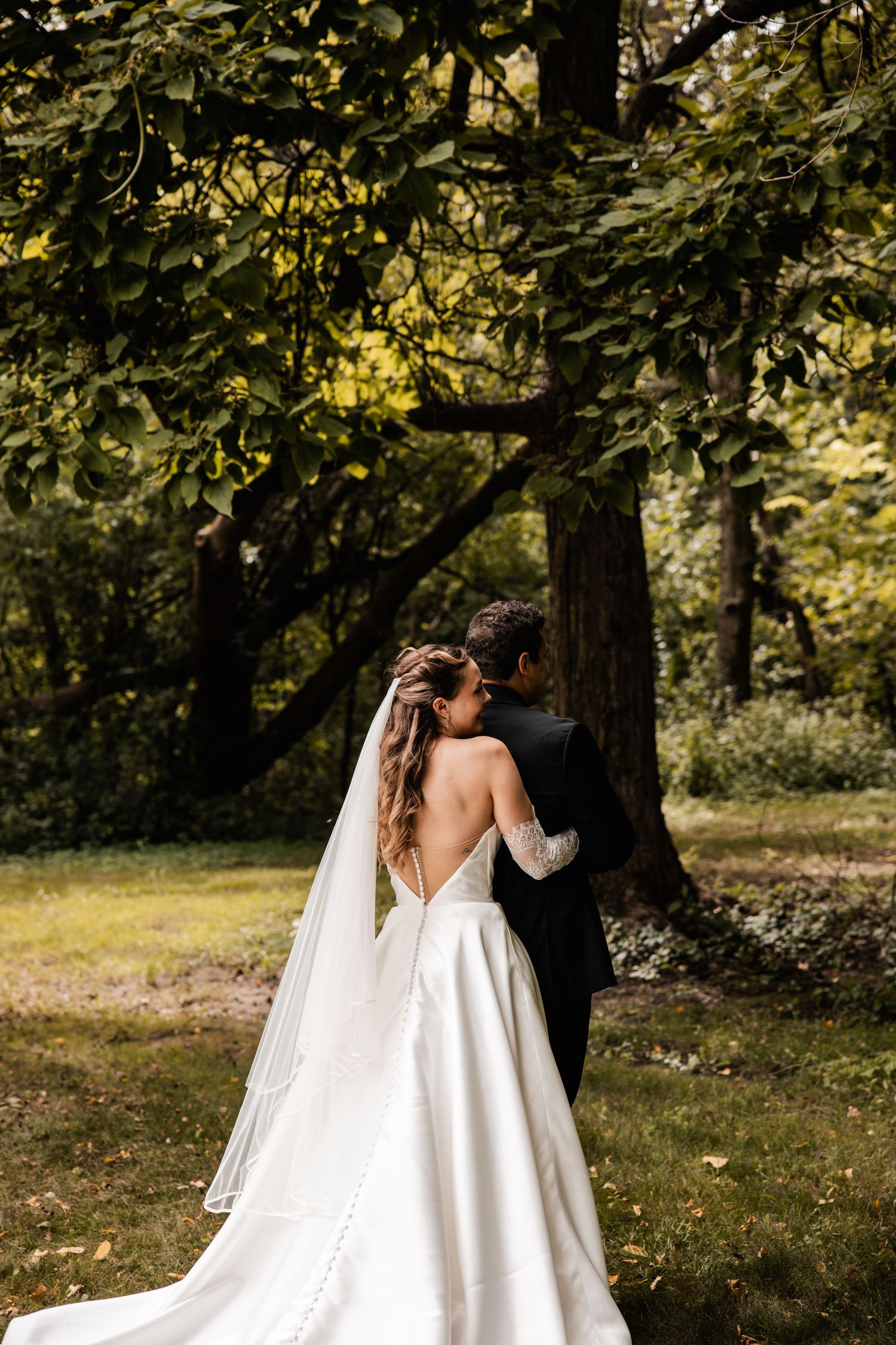 Wedding couple shares intimate moments in a series of photos taken in a scenic wooded outdoor setting.