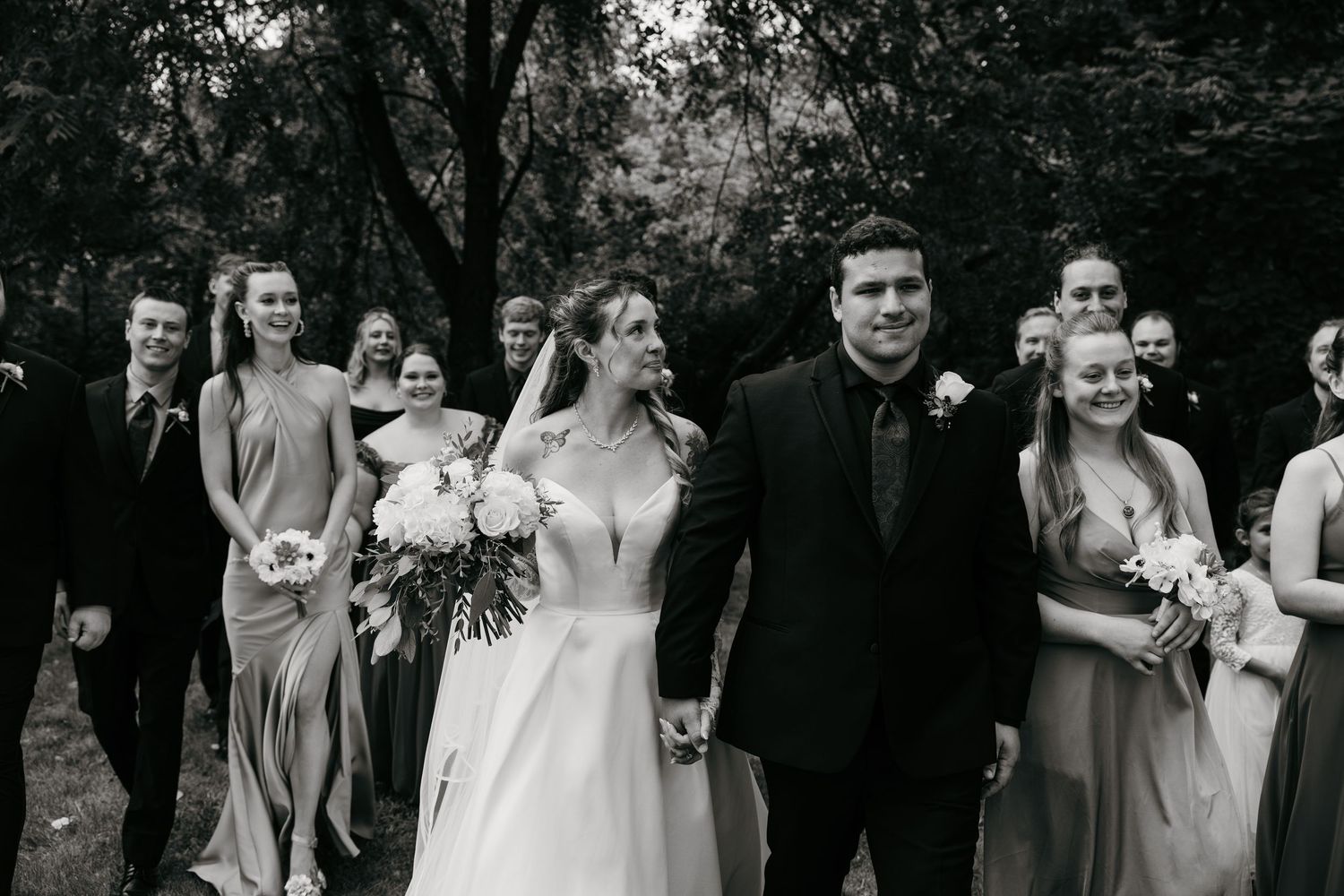 Black and white wedding party group photo sequence in an outdoor setting.