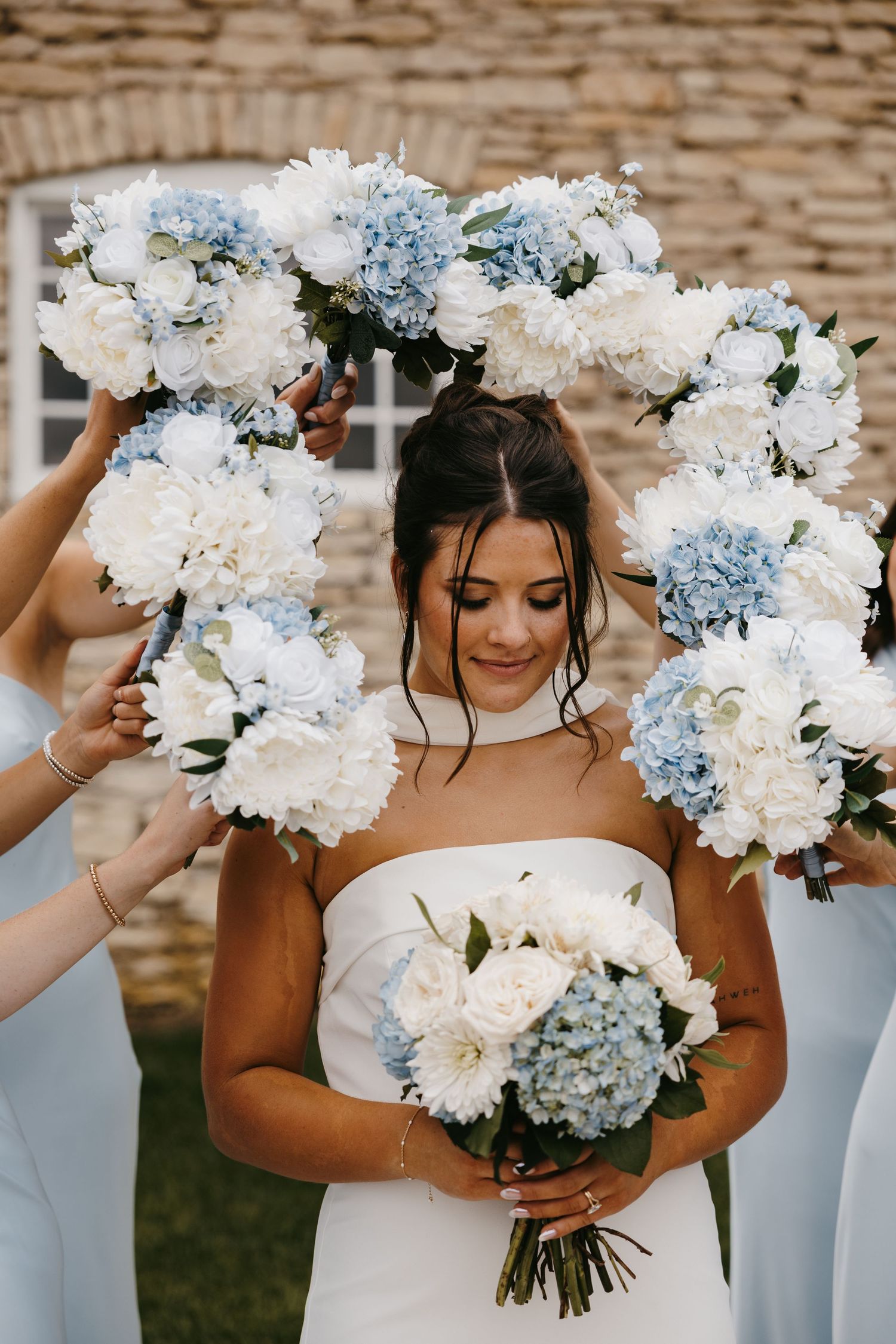 Beautiful blue and white hydrangea bouquets held by wedding party in light blue dresses.