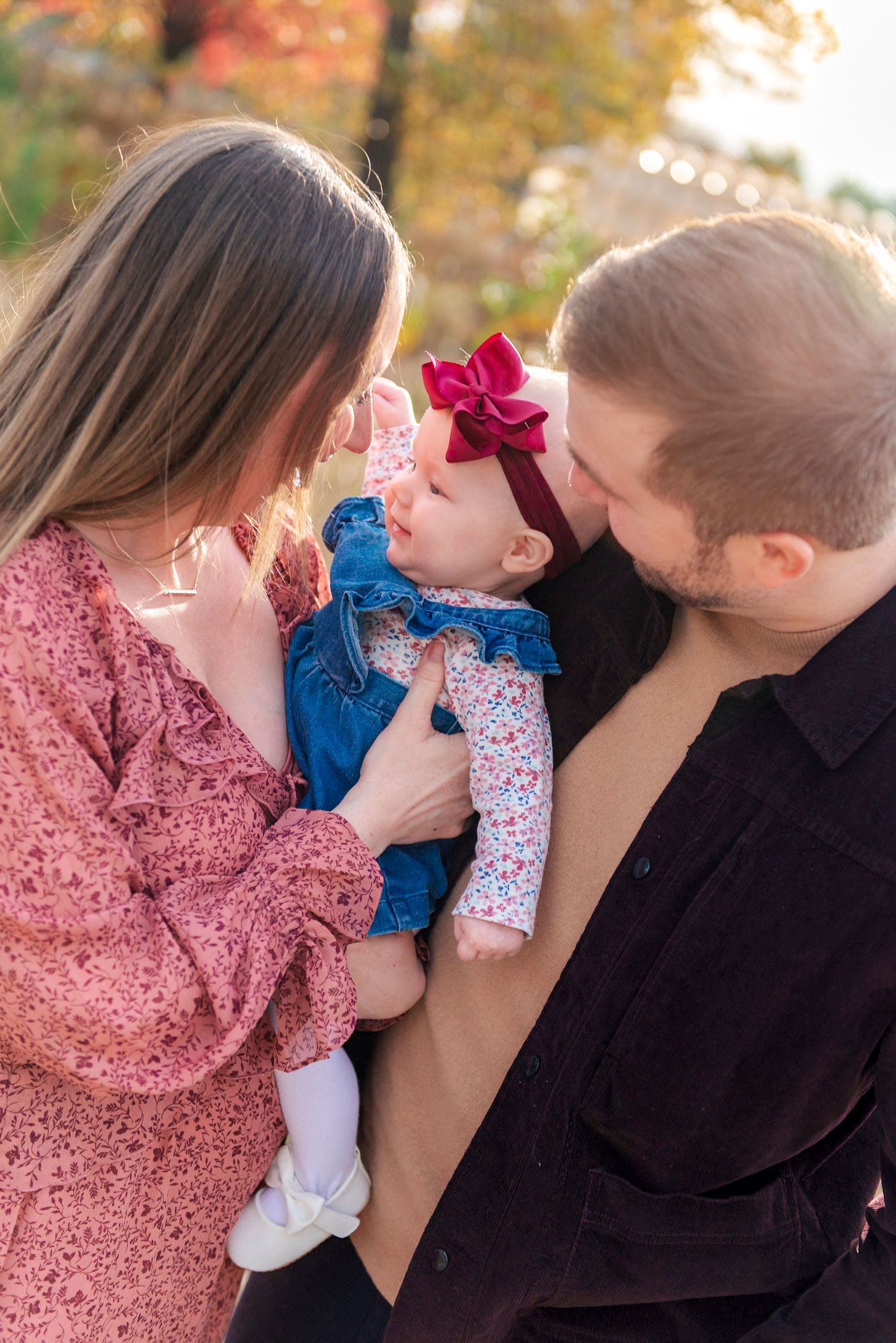 Parents snuggling with toddler during golden hour photo session in Lincoln Park